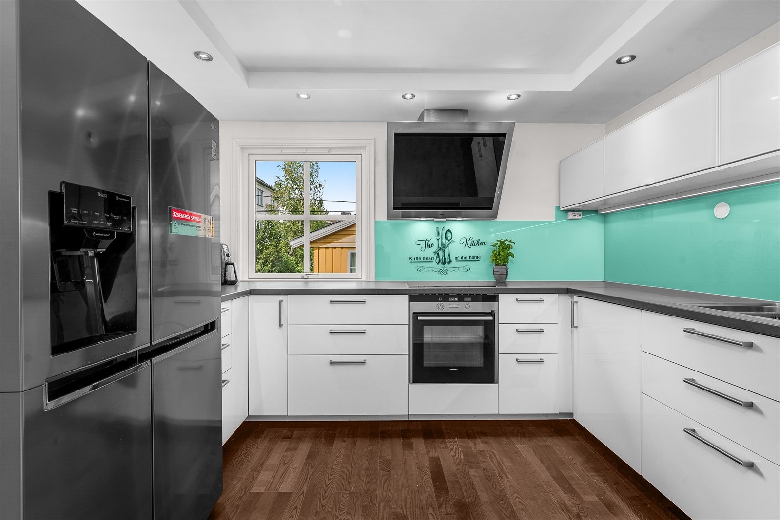 Kjøkken med glatte fronter, laminatbenkeplate og integrerte hvitevarer gir et stilrent inntrykk. Galleribilde