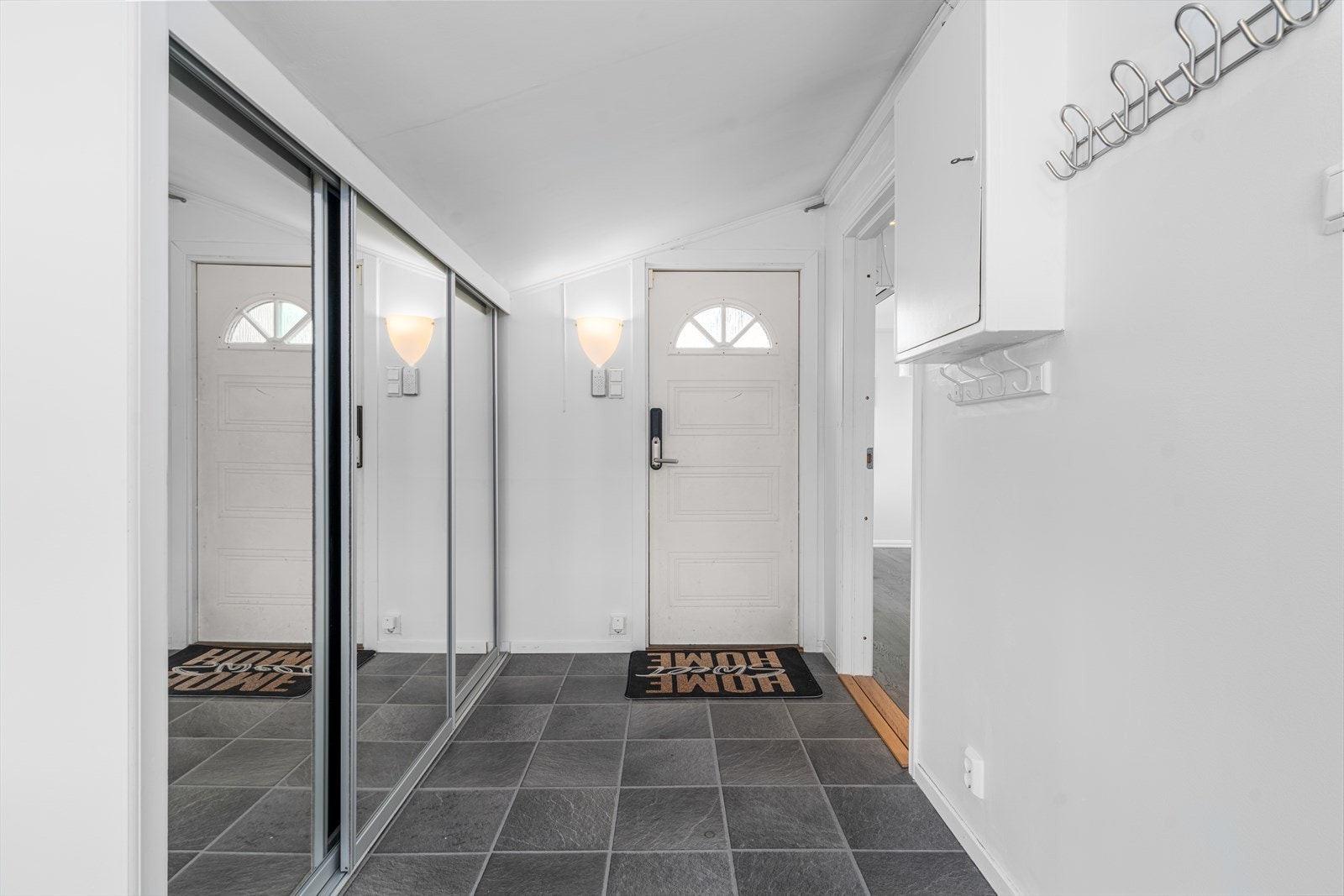 Entré med elektrisk dørlås og speilskyvedørsgarderobe for praktisk oppbevaring. Galleribilde