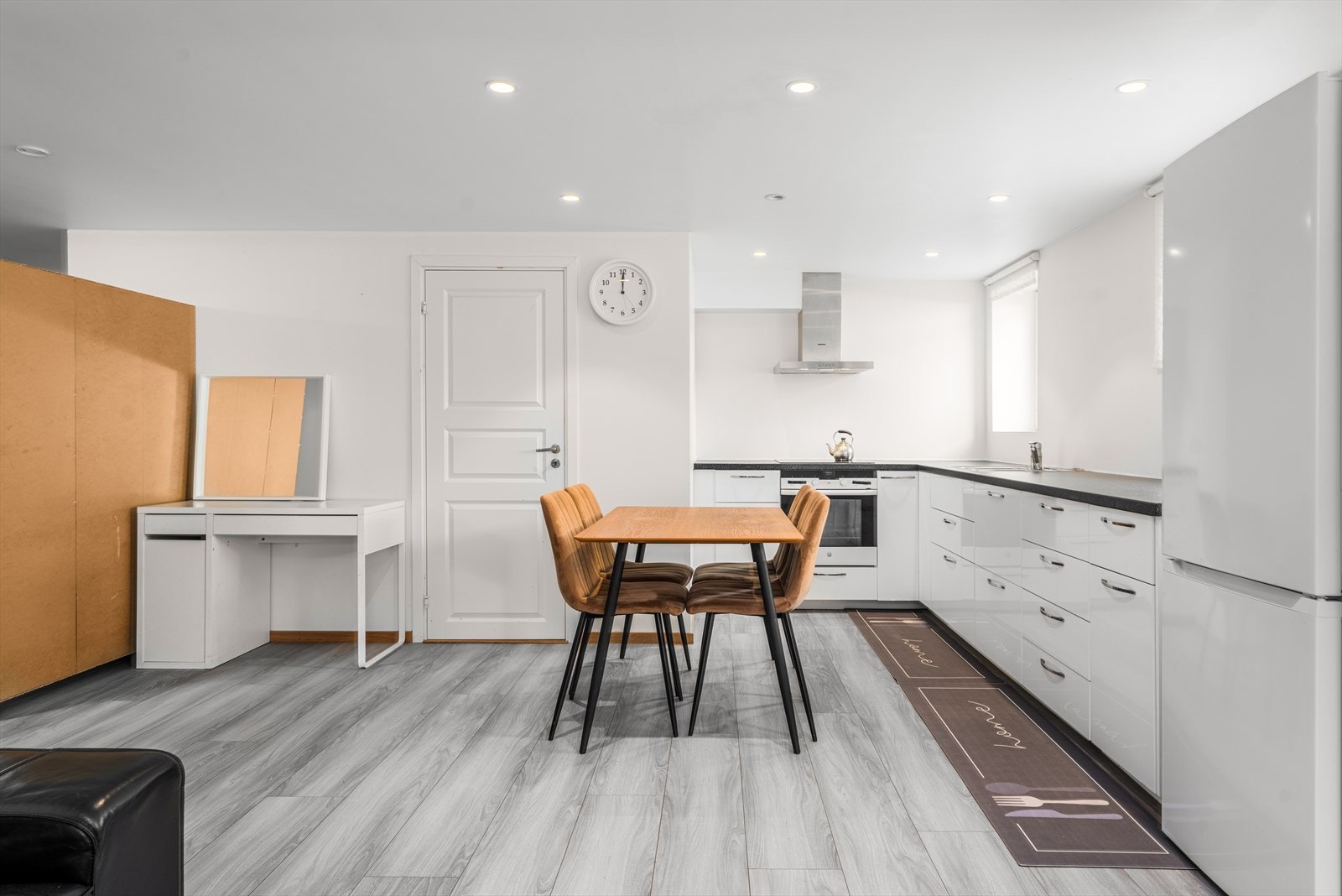 Kjøkken i utleiedel med glatte fronter, platetopp, komfyr og spiseplass. Galleribilde