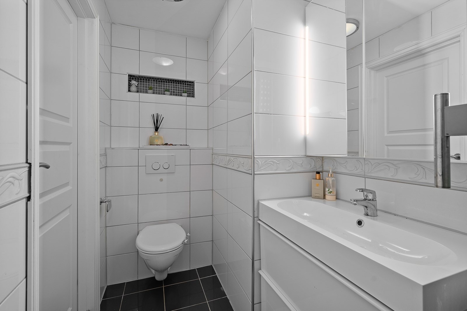 Stilrent bad med varmekabler i gulv og moderne servantinnredning for ekstra komfort. Galleribilde