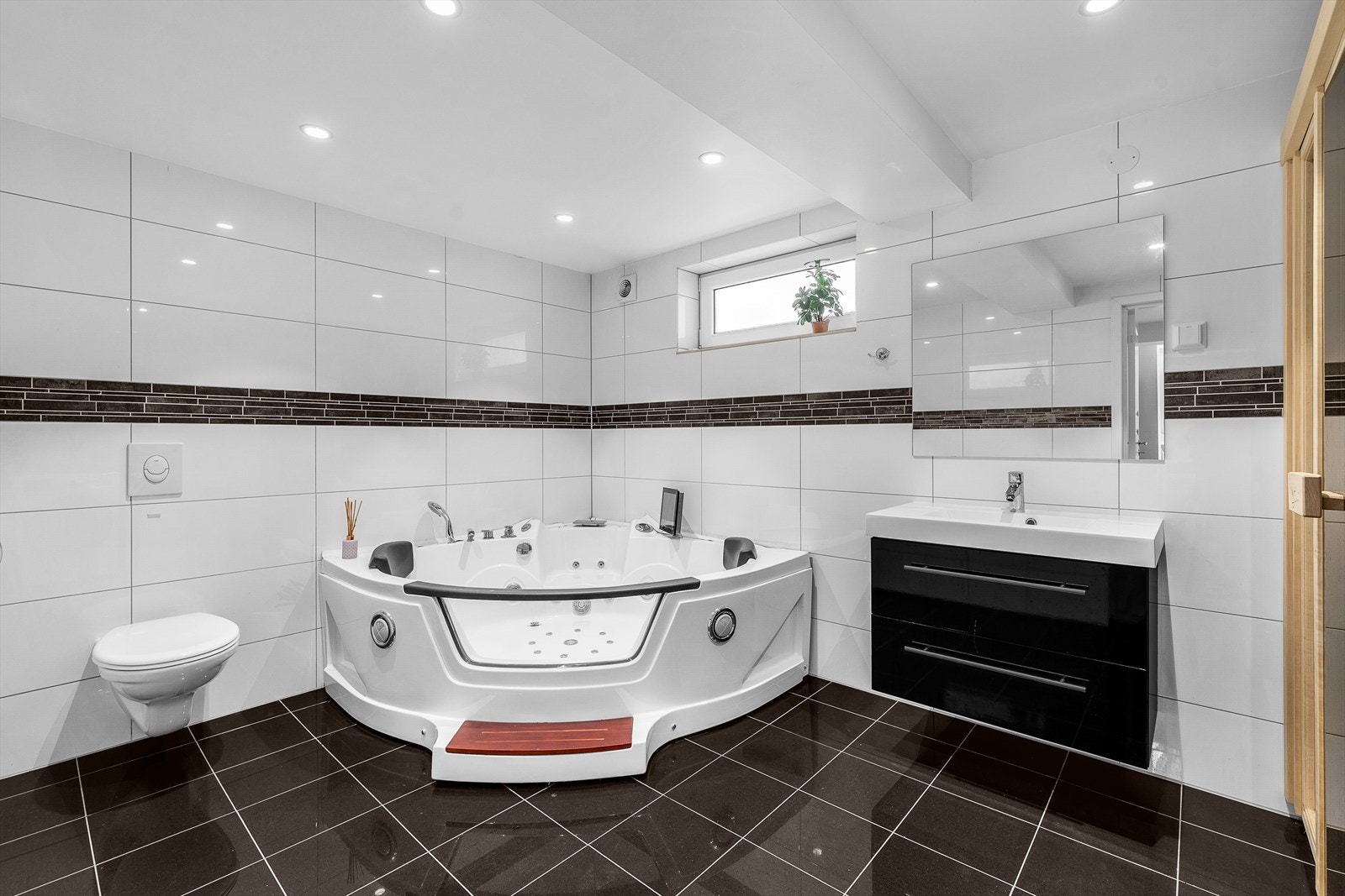 Spa-inspirert bad med hjørnebadekar, downlights og vegghengt toalett for optimal komfort. Galleribilde