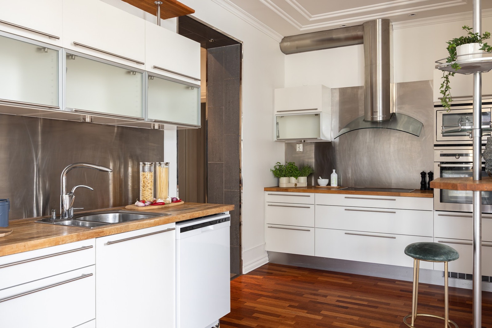 Integrerte hvitevarer fra AEG som består av oppvaskmaskin, mikrobølgeovn, komfyr, keramisk platetopp og kjøleskap med fryser. Galleribilde