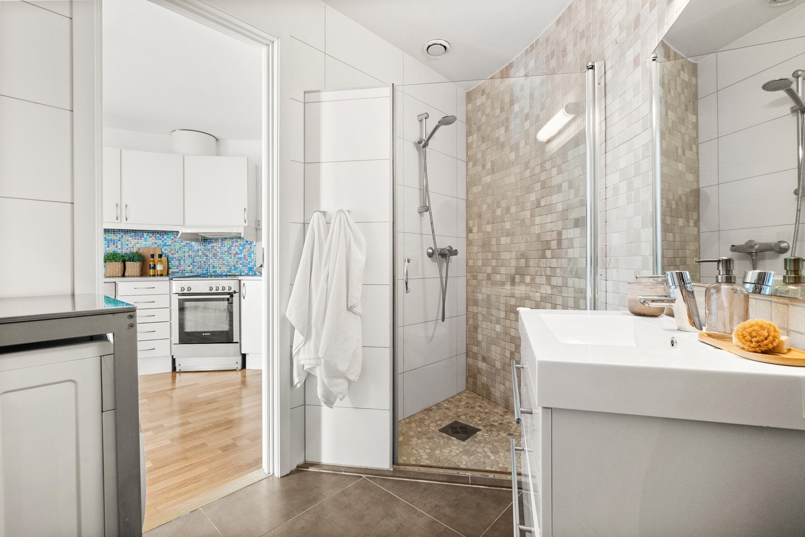 Videre utstyrt med dusjhjørne, vegghengt toalett og opplegg for vaskemaskin. Galleribilde