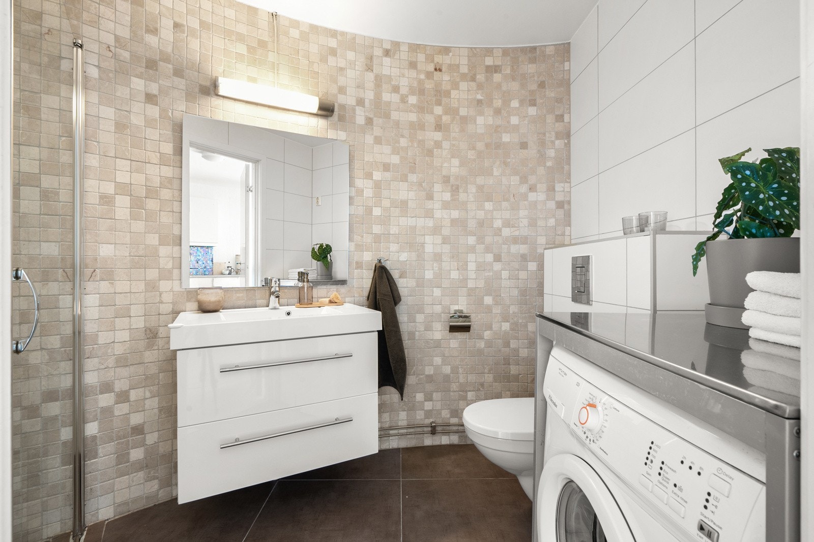 Leiligheten har et pent og flislagt baderom. Galleribilde