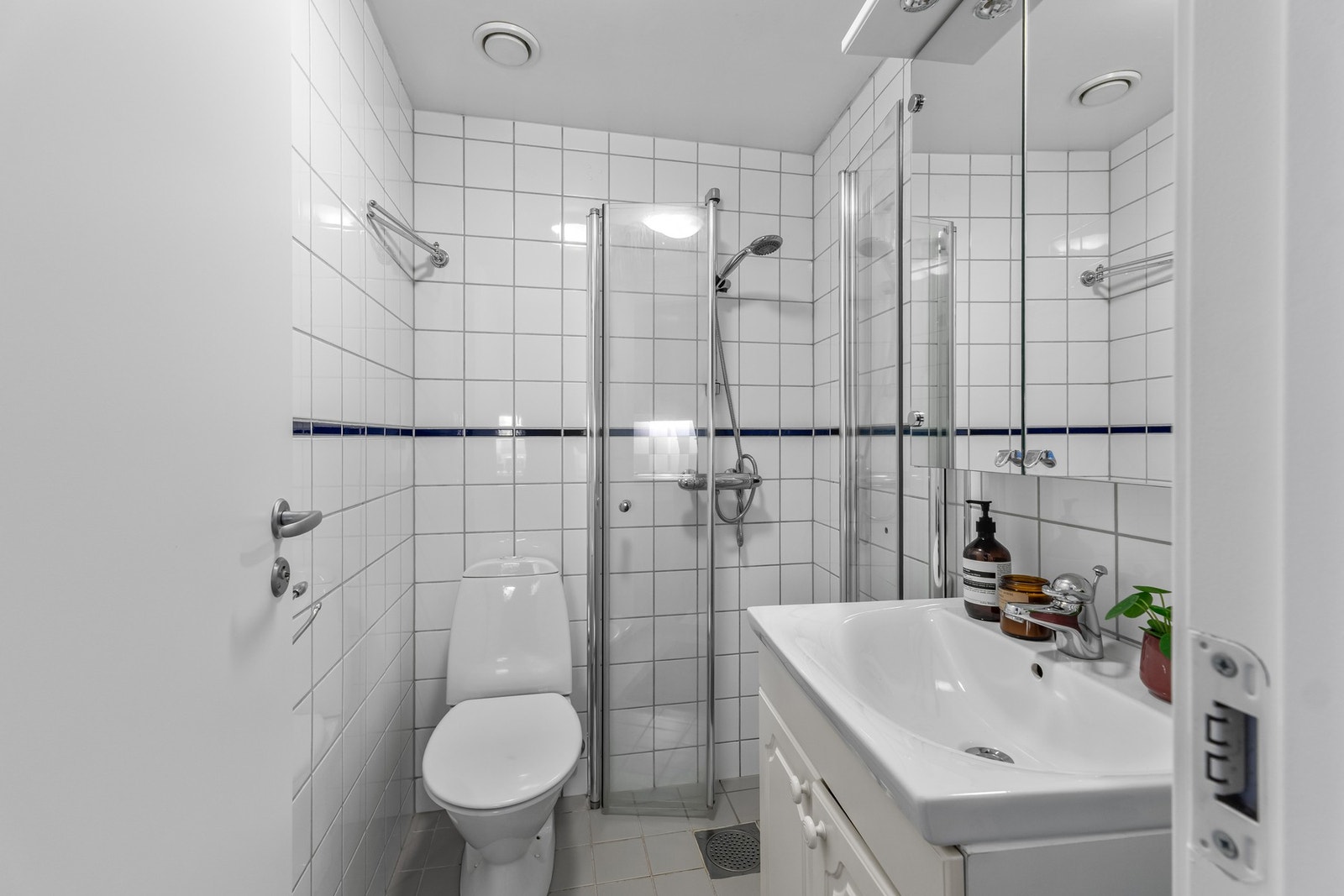 Pent, flislagt bad med varme i gulv og malt himling. Badet er innredet med servant med oppbevaringsplass, toalett og dusjhjørne. Galleribilde