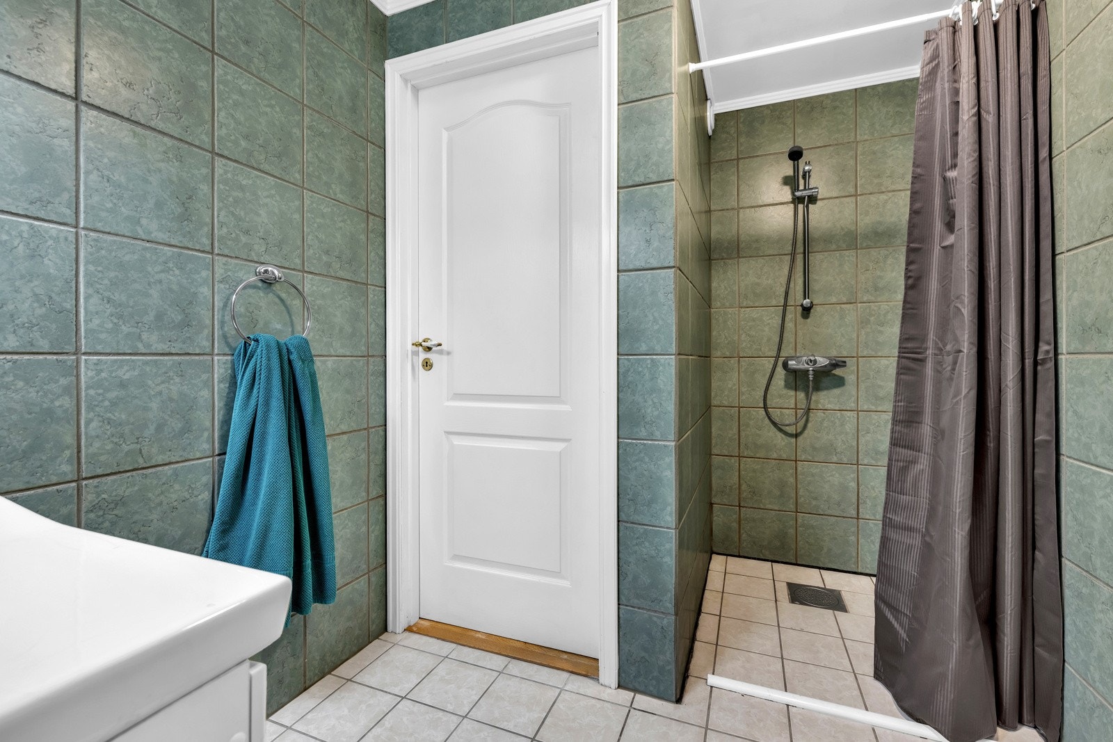 Her får du dusjnisje med dusjforheng og veggmontert armatur, gulvstående toalett og opplegg for vaskemaskin. Galleribilde