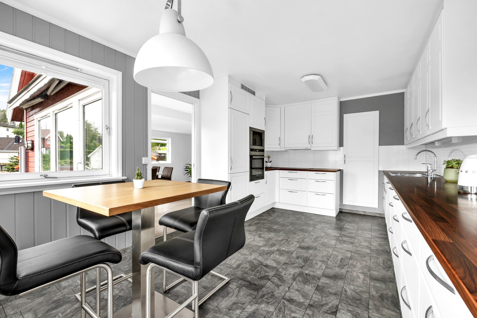 Kjøkkenet ligger separat fra stuen og har laminat på gulvene som står godt til den gråmalte panelen på veggene. Galleribilde