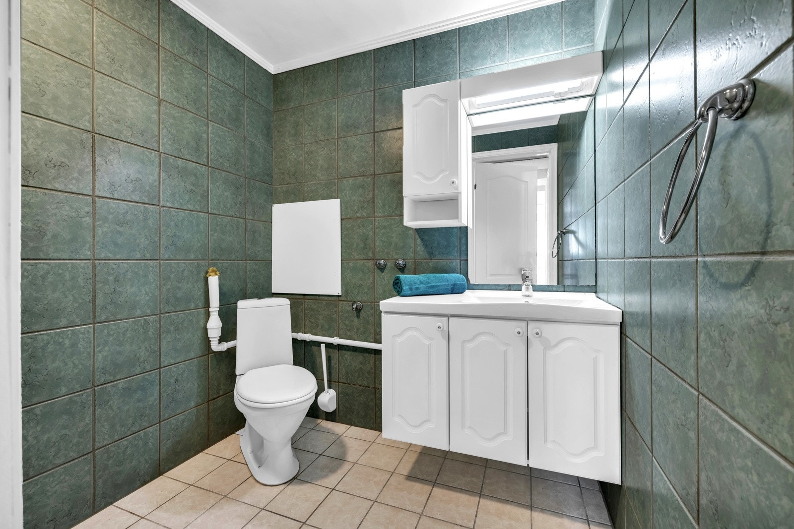 Boligens andre bad ligger i kjelleren og har flislagte gulv og vegger og har elektrisk gulvvarme. Badet er fra 2003 og er utstyrt med vegghengt servantinnredning med overpåliggende servant. Galleribilde