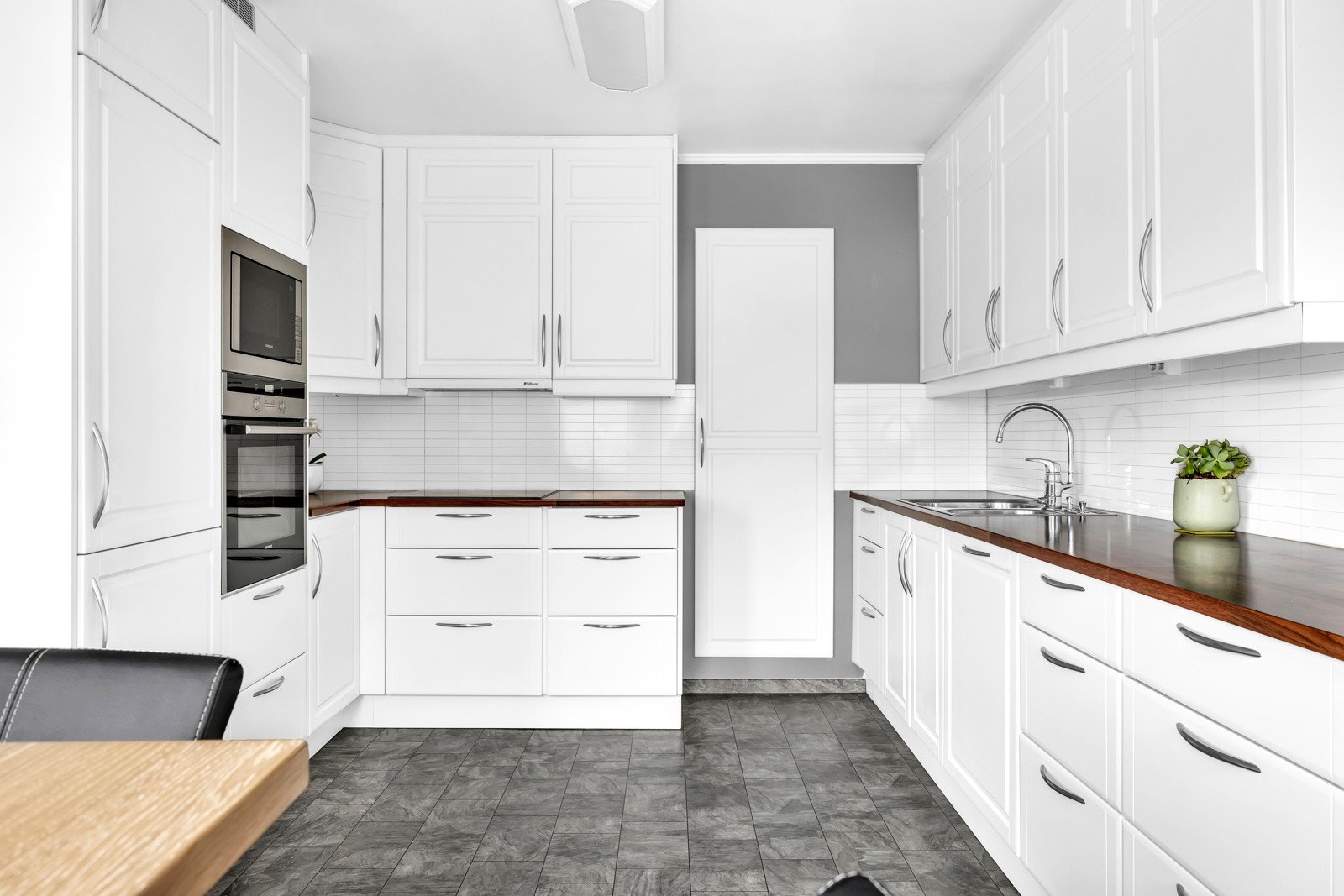 Kjøkkenet er utstyrt med en nedsenket oppvaskkum med ett-greps armatur, plater i sprutsone mellom benkeplate og overskap. Galleribilde