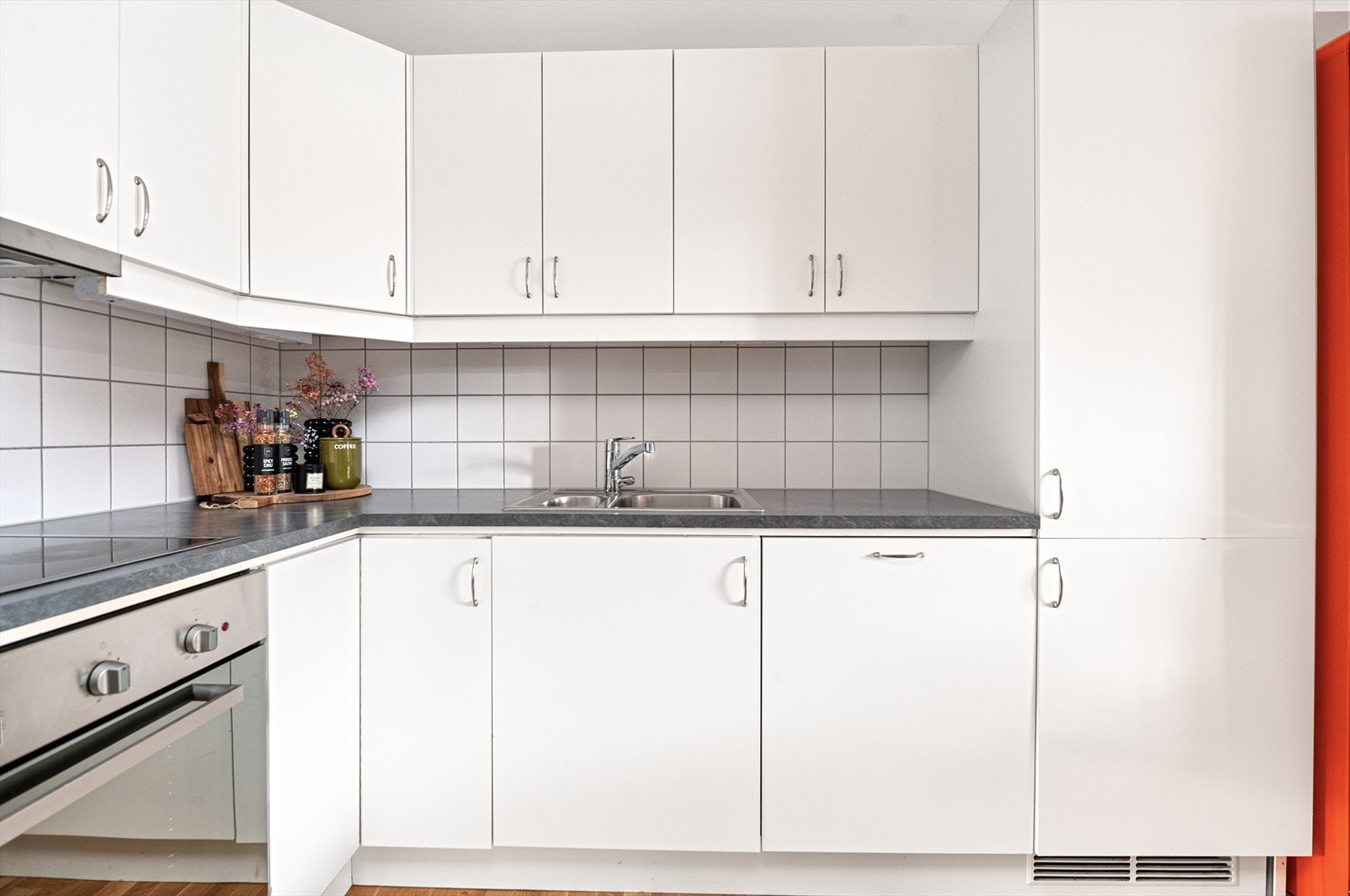 Kjøkkenet er utstyrt med integrerte hvitevarer bestående av kombiskap, oppvaskmaskin, ventilator, platetopp og stekeovn Galleribilde