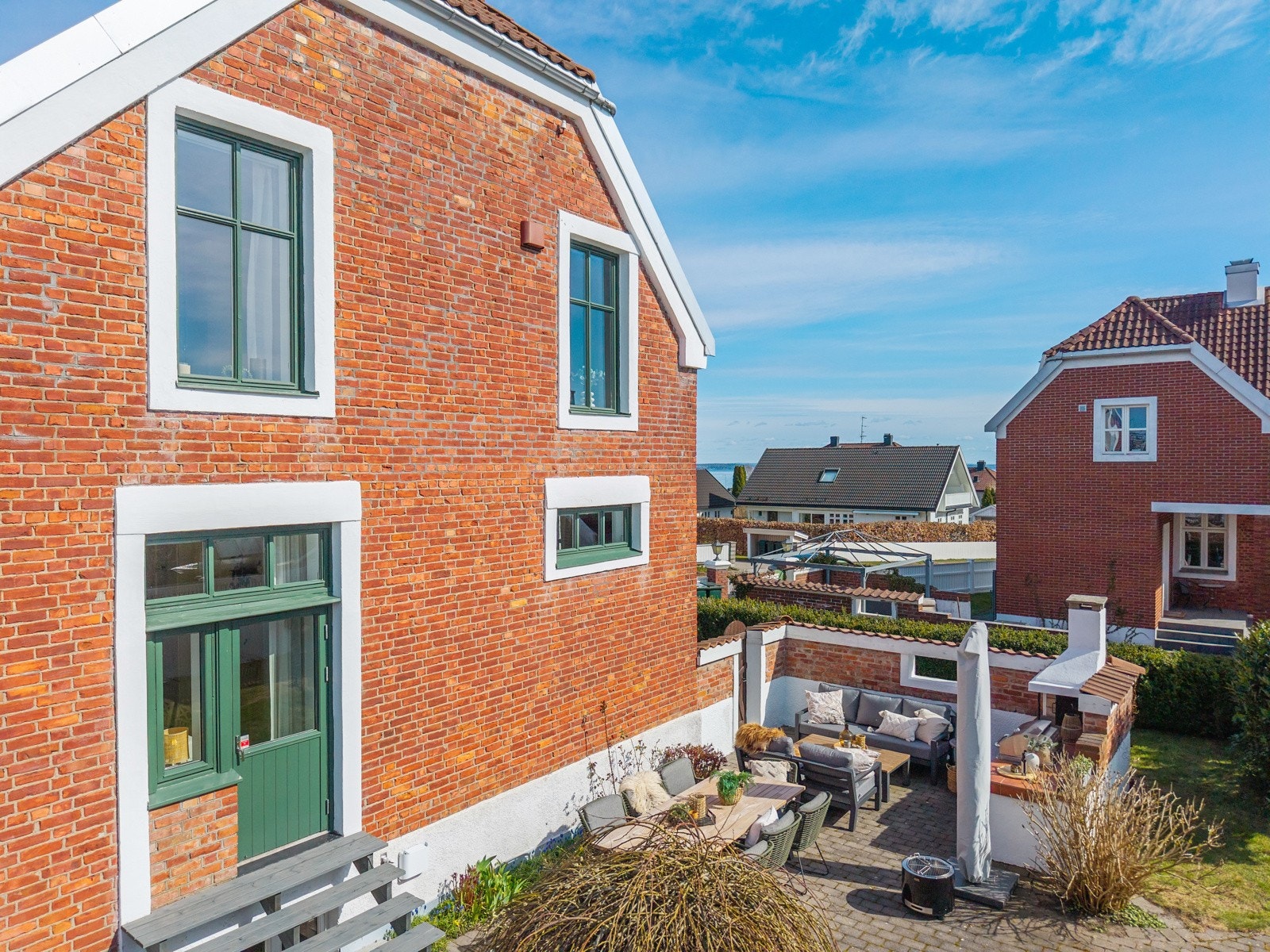 Rett på utsiden av kjøkken/allrommet finner vi en lun og solrik uteplass med sommerkjøkken Galleribilde