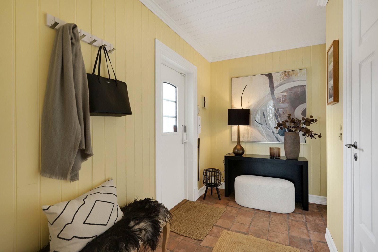 Romslig entre med flislagt gulv, garderobeplass og skoskap med hyller Galleribilde