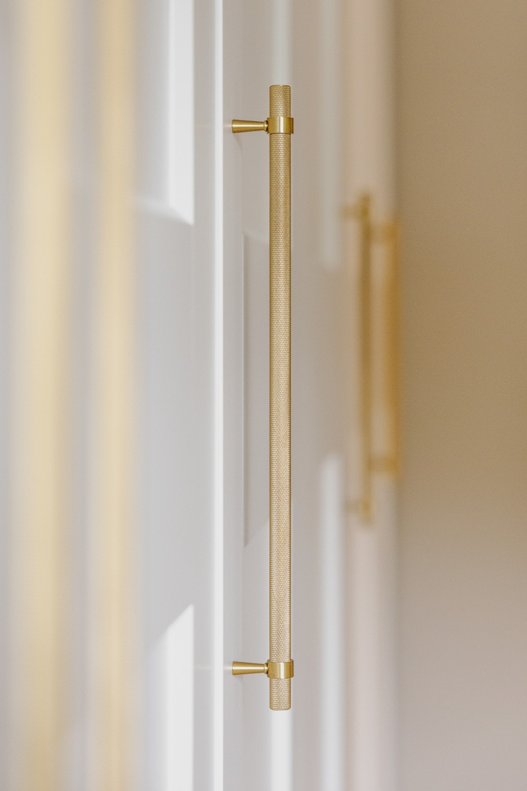 Store garderober gir rikelig med oppbevaringsplass, samtidig som rommet fremstår ryddig og stilrent - lekre håndtak i messing fra Lovehandles Galleribilde