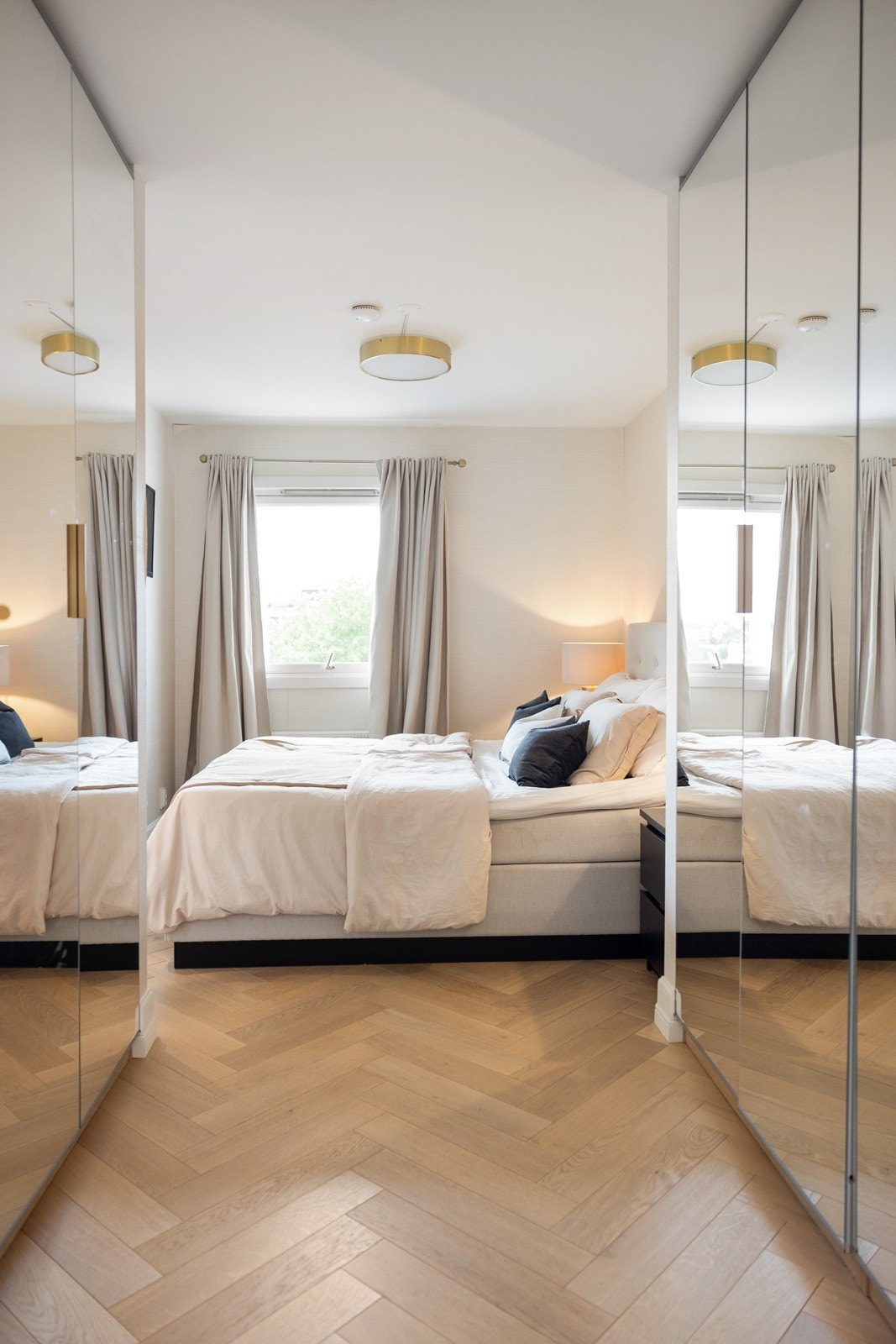 Speilfronter på garderobeskap forsterker romfølelsen, og det elegante fiskebensgulvet i eik gir en eksklusiv finish Galleribilde