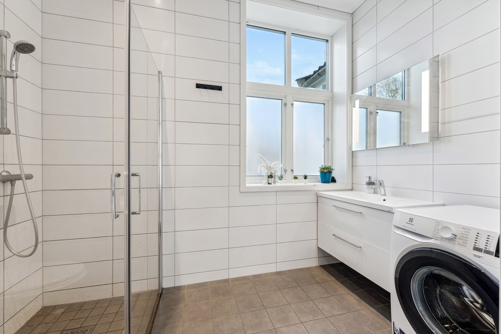 Badet har pene, flislagte overflater, varme i gulvet og downlights i himling. Galleribilde