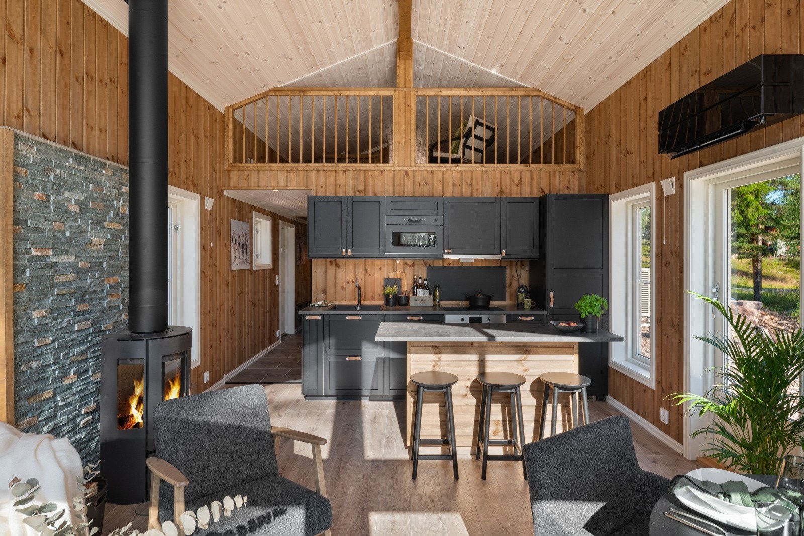 Åpen kjøkken/stueløsning med komplett kjøkken med alle hvitevarer, praktisk kjøkkenøy, peisovn og varmepumpe. Galleribilde