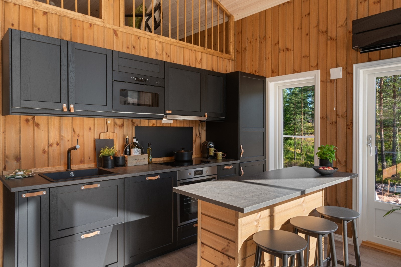 Lerhyttan kjøkken med oppvaskmaskin, komfyr, induksjonstopp, kjøl og frys, mikro og praktisk kjøkkenøy. Galleribilde