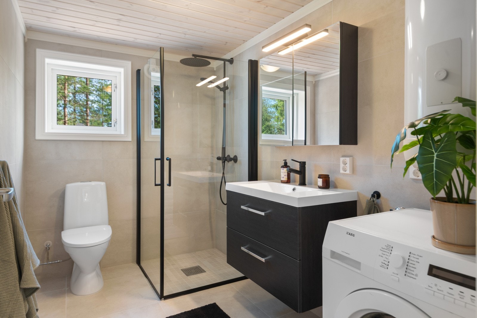 Stort og lekkert flislagt bad med varmekabler, 90x90 innsvingbare dusjdører, wc, Lind Luxery 80 cm baderomsinnredning, varmvannstank og opplegg klart til vaskemaskin Galleribilde