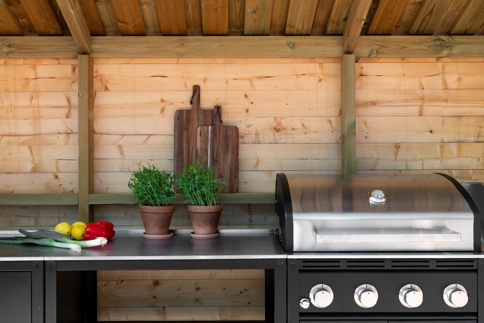 Flott, innbygd utekjøkken med grill, kokebluss, benker og skap samt innlagt vann og avløp. Galleribilde