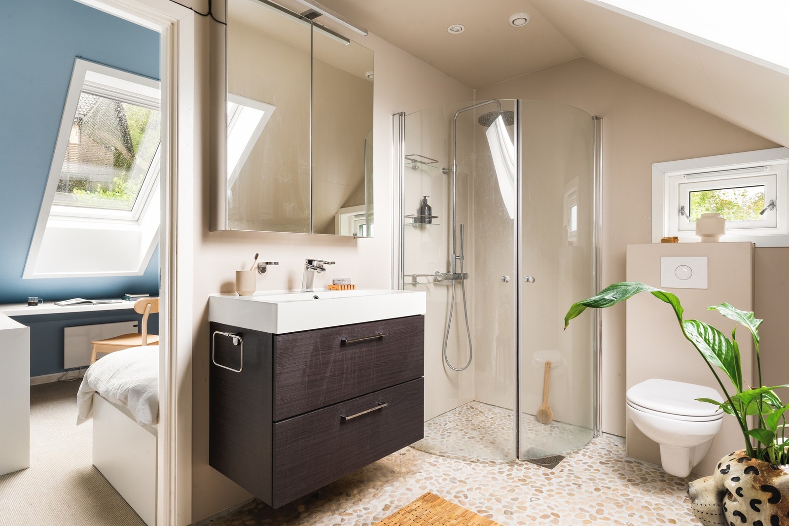 Et lyst og pent bad ligger praktisk til mellom soverommene. Badet er innredet med dusj, servant, toalett og skapplass. Vindu gir naturlig lys og ventilasjon, noe som gir en frisk og behagelig atmosfære. Galleribilde