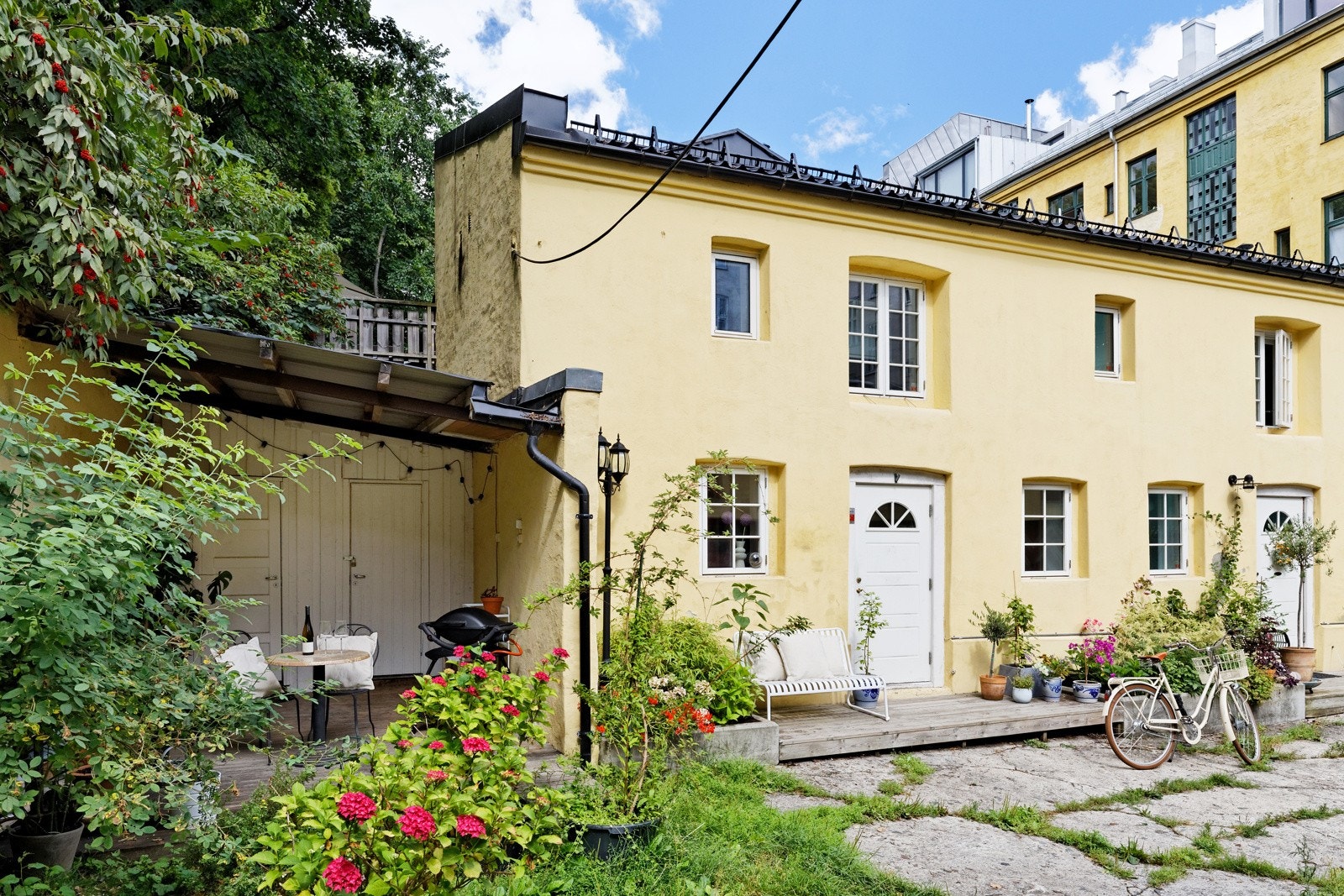 Idylliske omgivelser med beplantning, steinheller og hageflekk Galleribilde