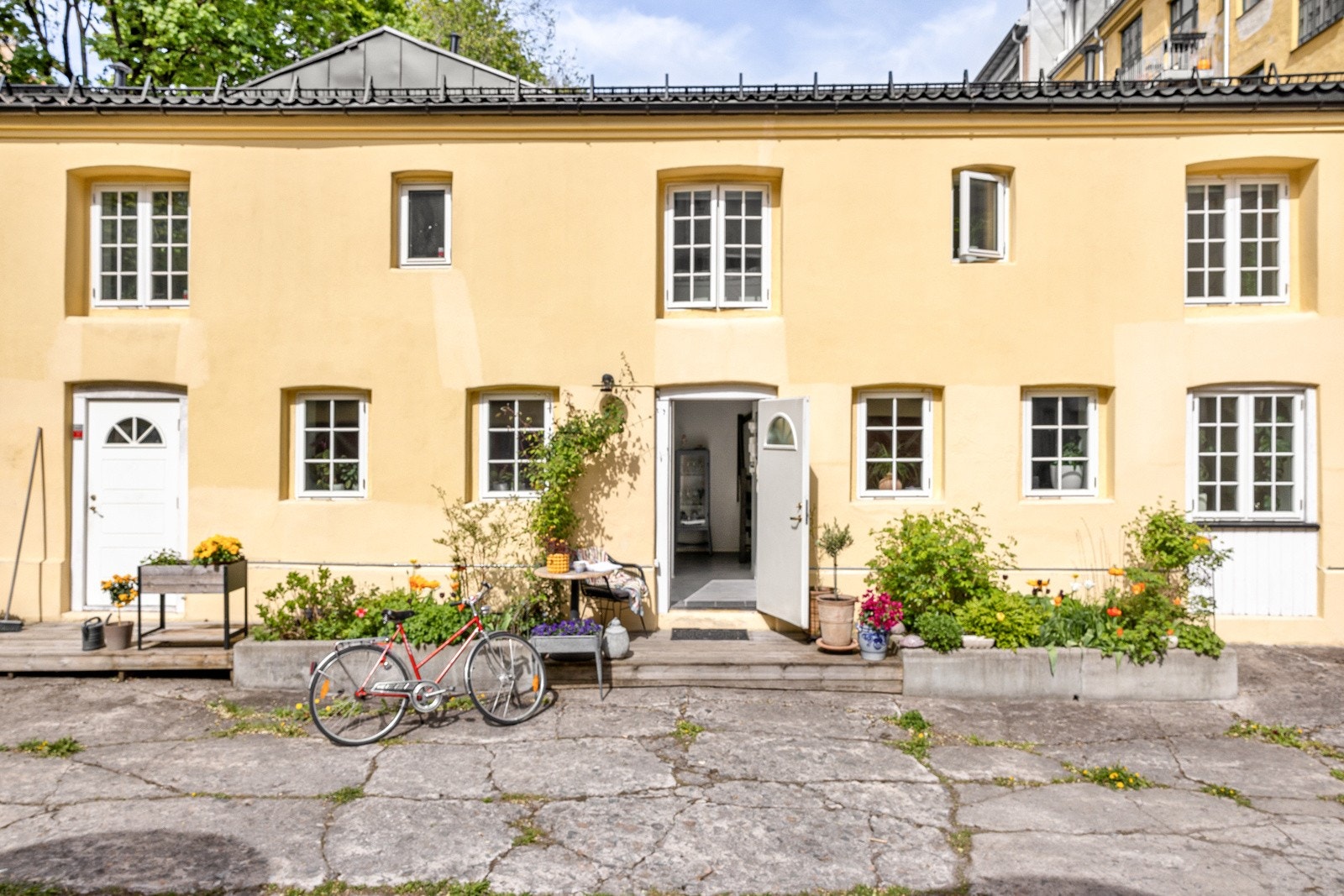 Det er en hyggelig inngang til boligen med platting hvor det er plass til sittegruppe Galleribilde