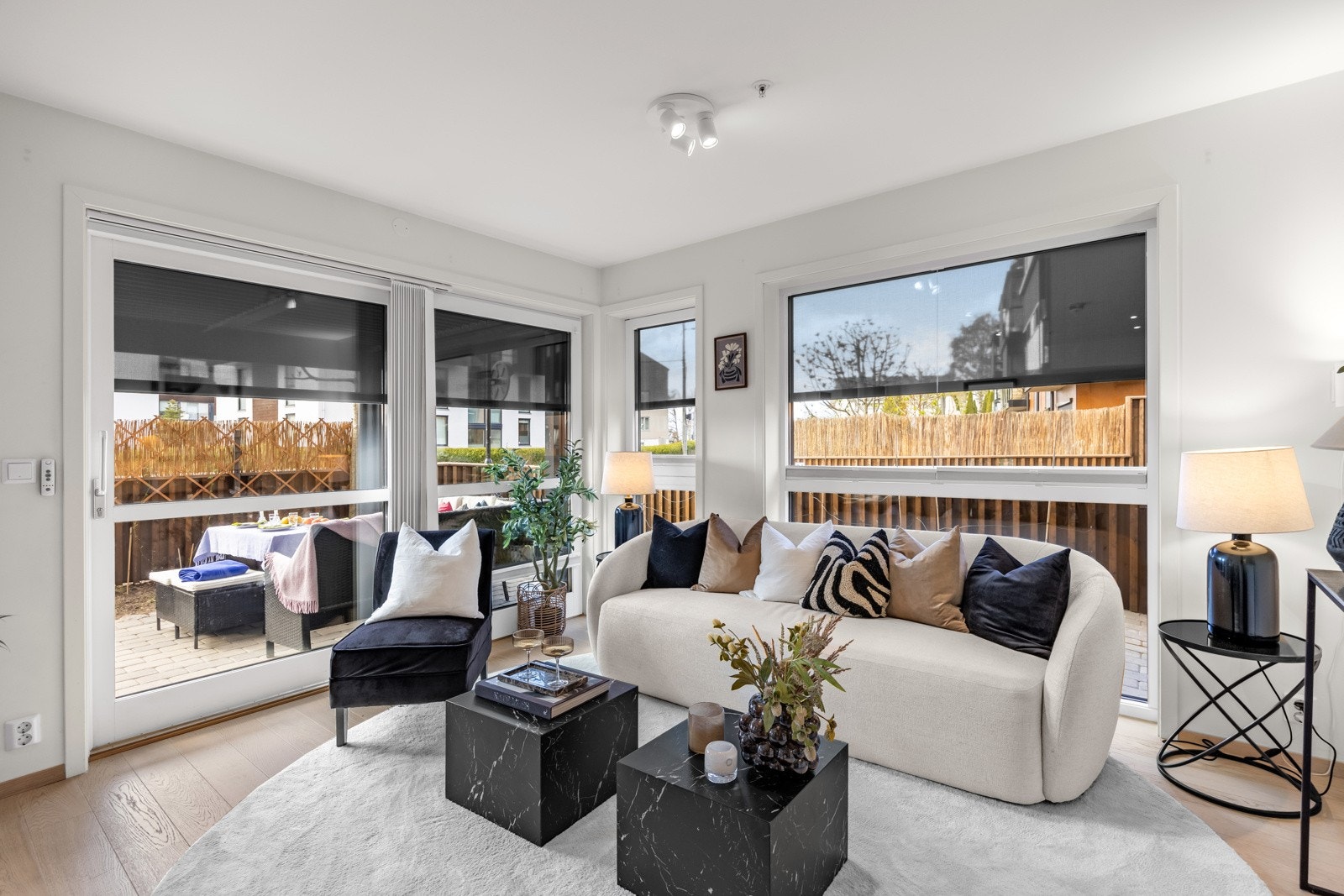 Utvendige screens og innvendige plisségardiner på vinduene i stuen Galleribilde