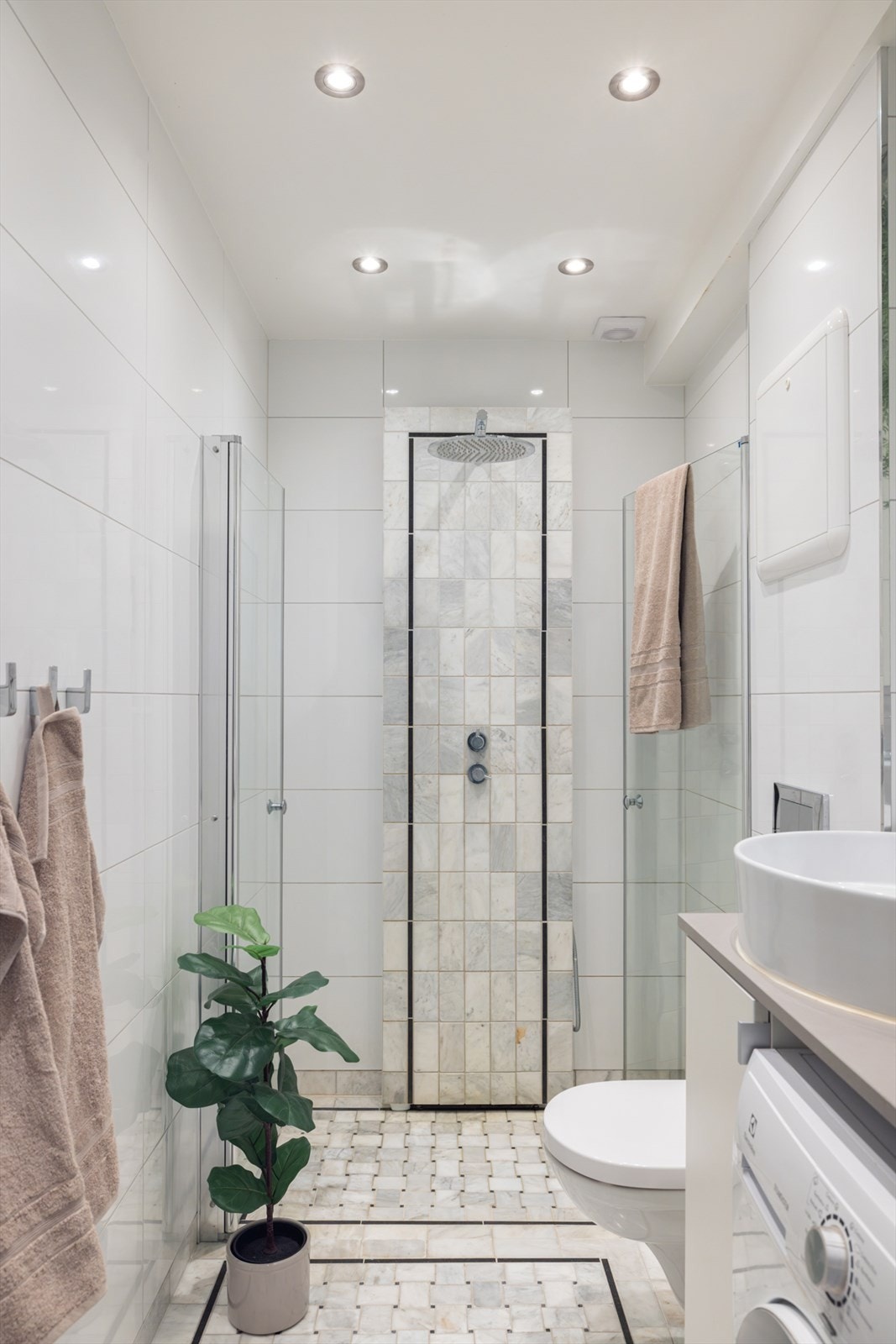 Innredningen består av servantskap med toppmontert servantskål, underskap og 1-greps blandebatteri. Dusjnisje med
glassdører og vegghengt toalett. Galleribilde