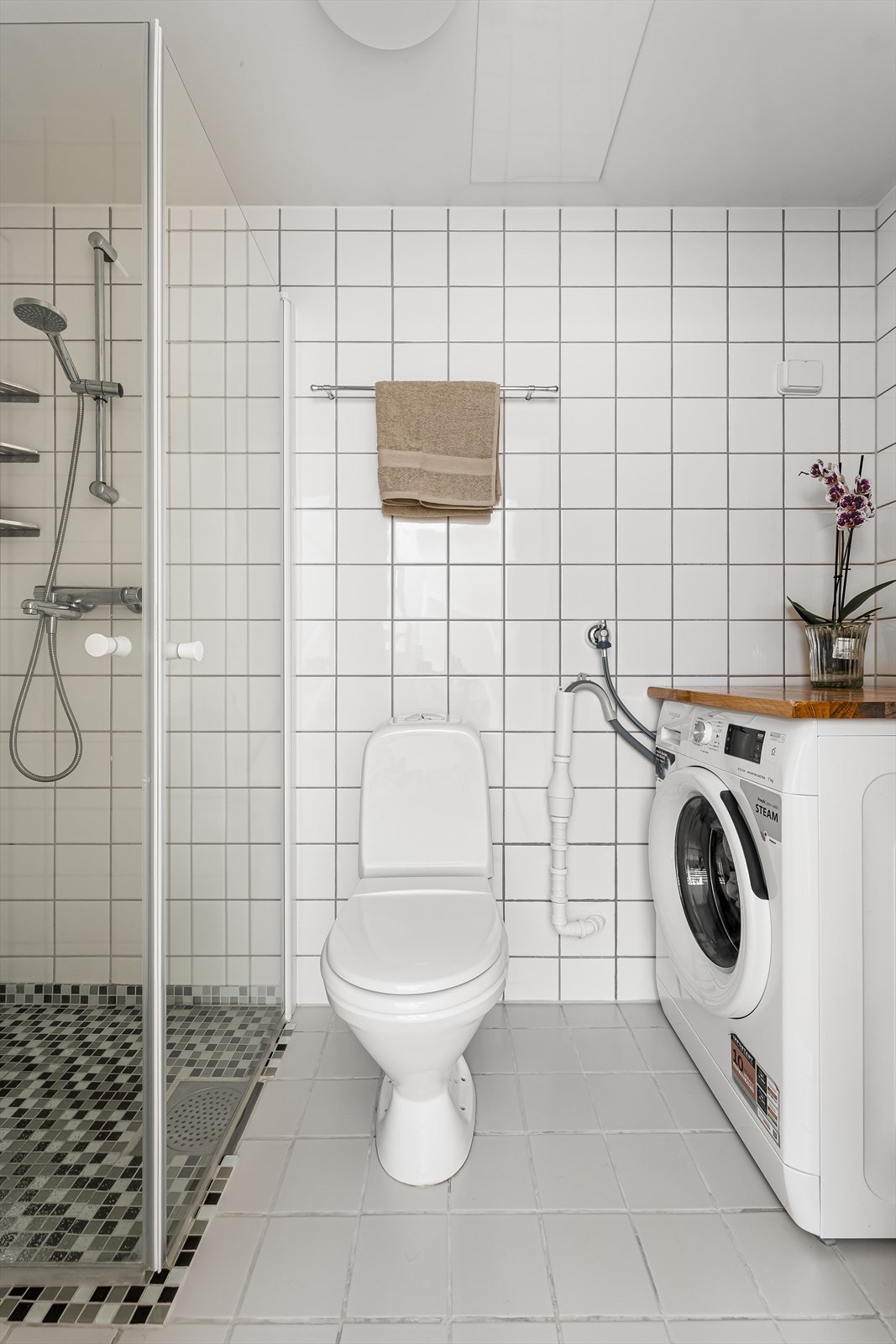 Baderom fra byggeår med flislagte vegger, malt himling og flislagt gulv med gulvvarme. Galleribilde