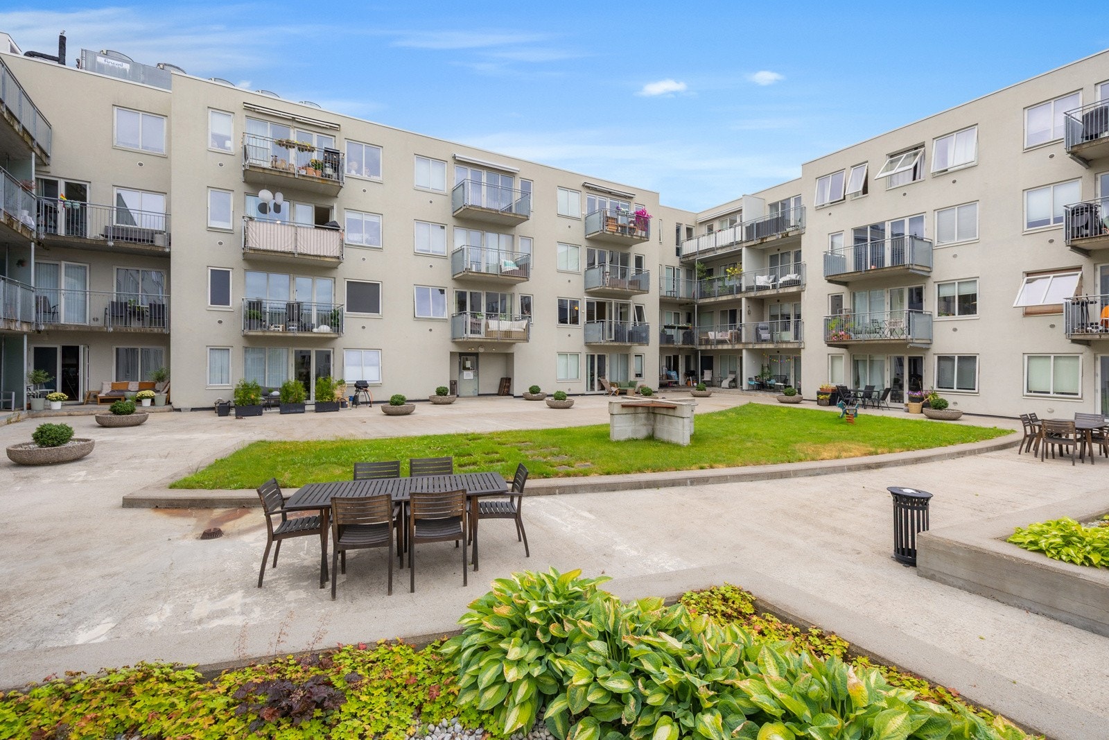 Beboerne disponerer en stor og fin bakgård, med gressplen, beplantning og flere sitteplasser Galleribilde