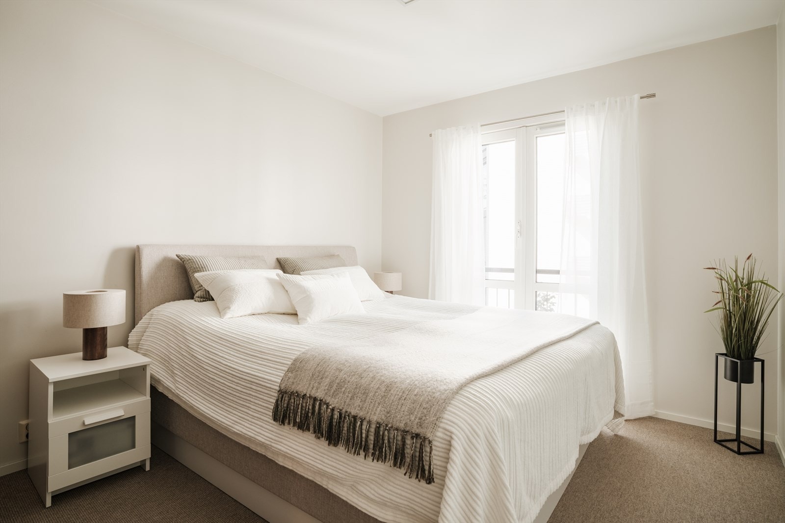 Naturlig plass til stor dobbeltseng og nattbord. Behagelig med vegg til vegg teppe på gulv. Galleribilde