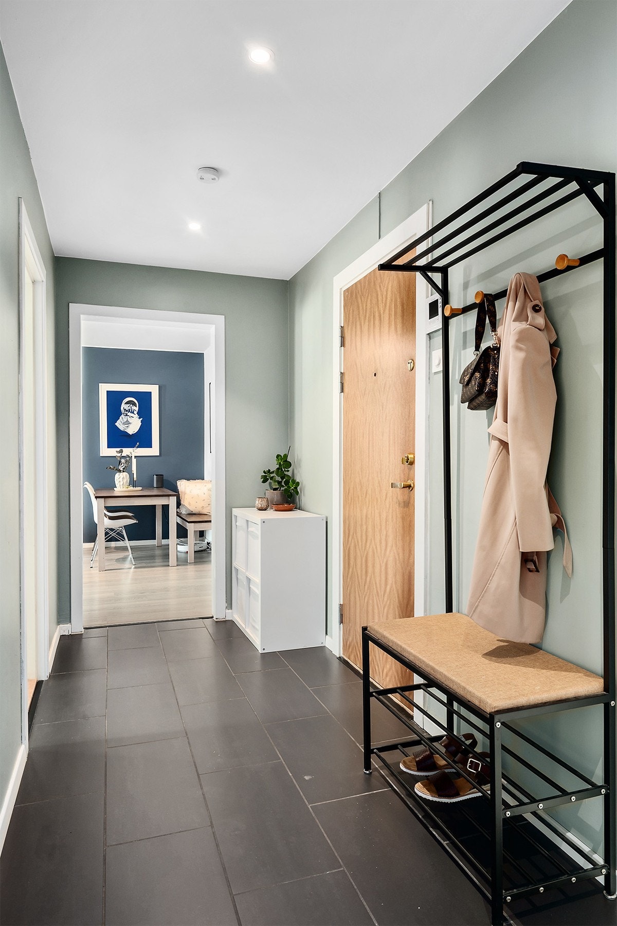 Her ønskes du velkommen inn i en hyggelig entré, hvor det er mulighet for å henge fra seg yttertøy og sette fra seg sko. Det er fliser på gulvet som er praktisk med tanke på våte klær og sko. Galleribilde