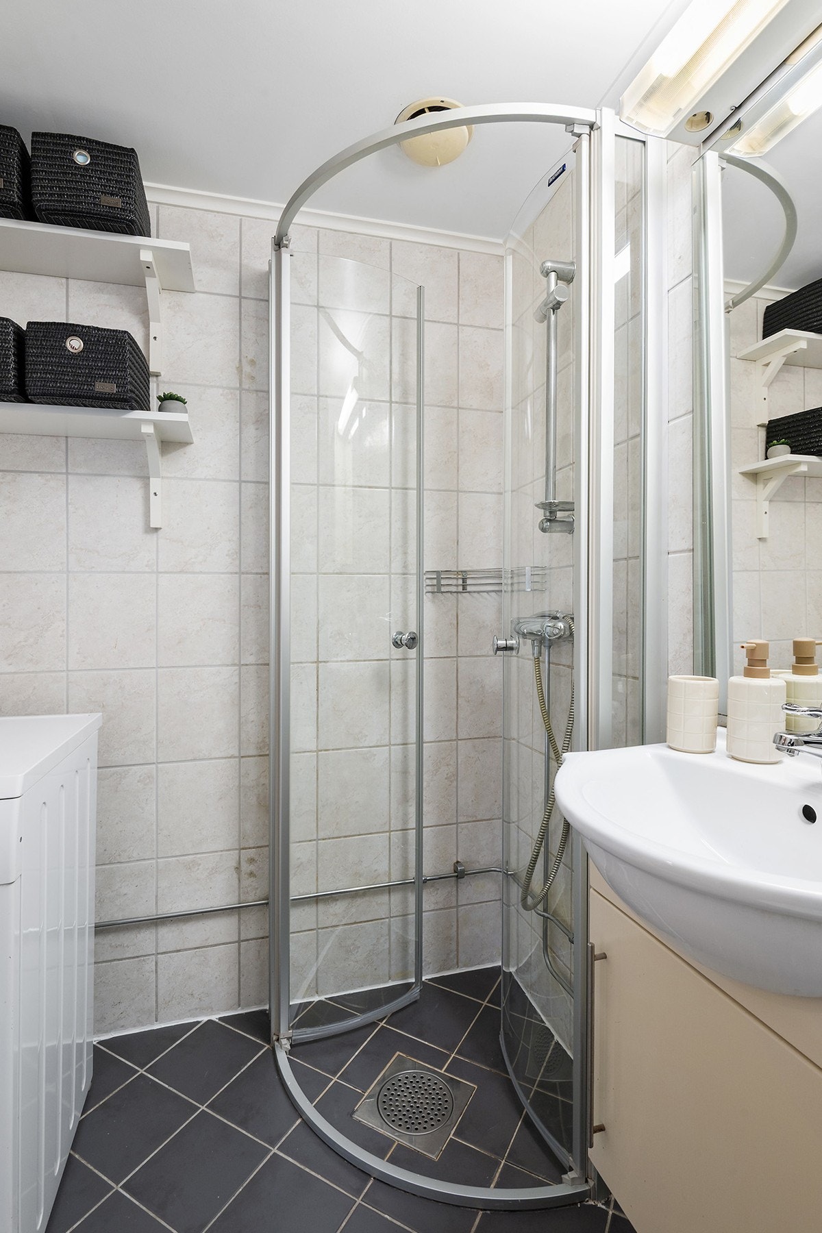 Badet har dusjhjrørne med skyvedører og opplegg for vaskemaskin. Galleribilde