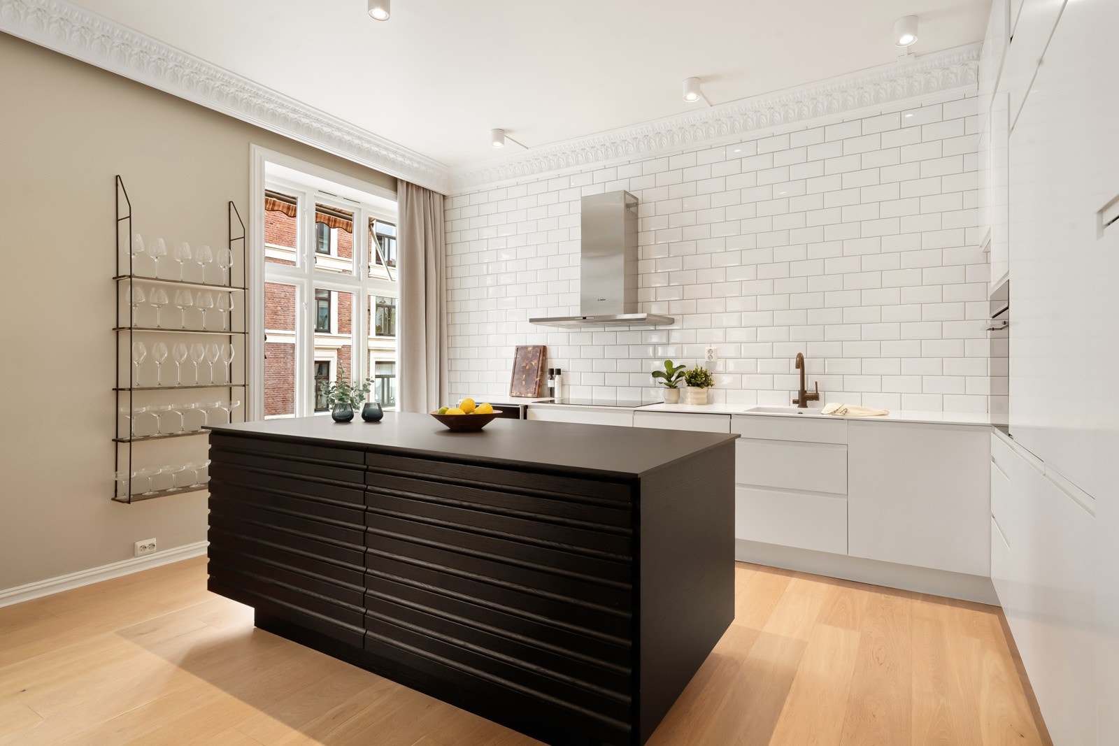 Kjøkkenen fra epoq som er utformet uten overskap, med flislagt vegg i klassisk hvit som gir et rent og tidløst uttrykk. Galleribilde