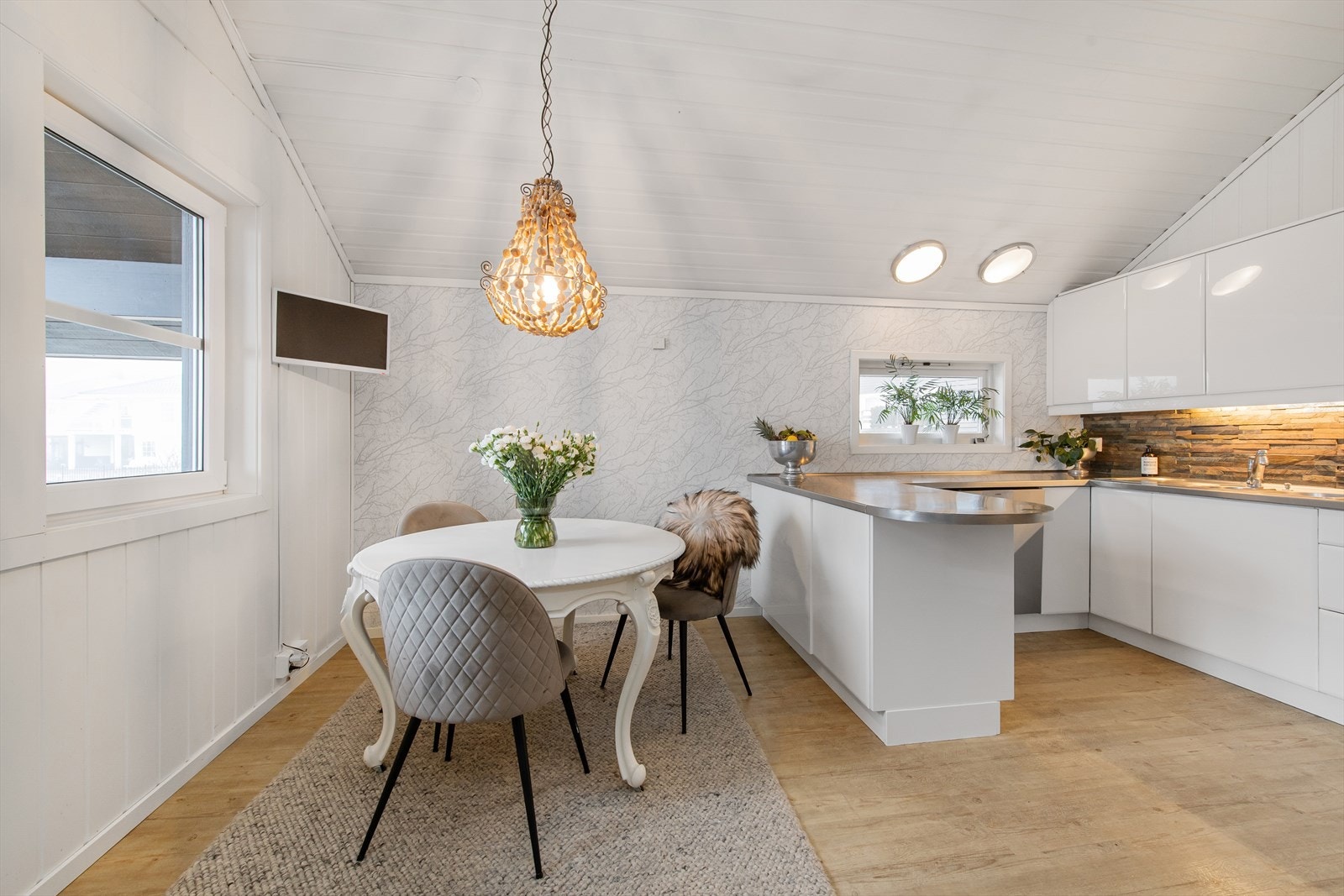 Kjøkken med lyssetting og spiseområde. Galleribilde