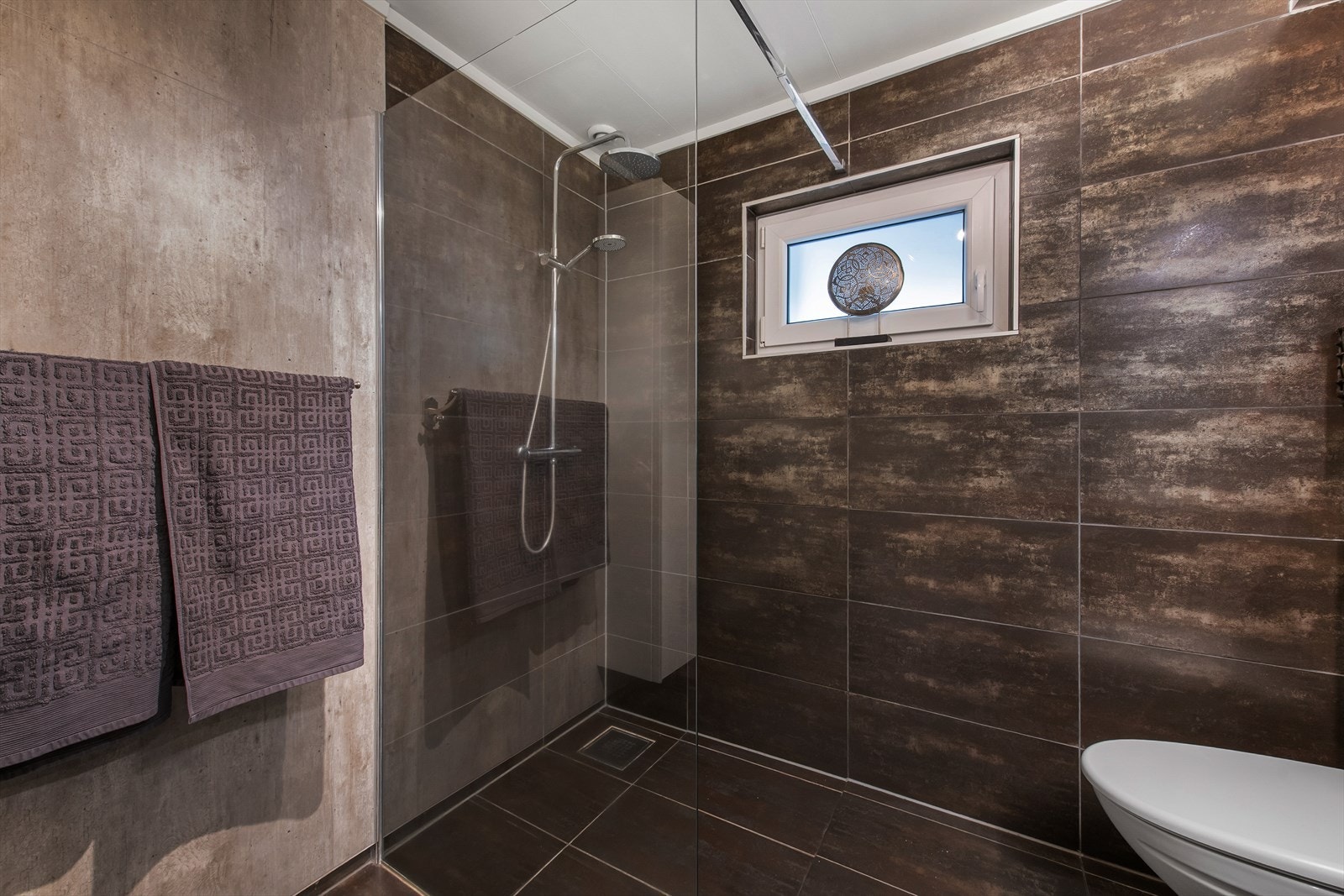 Dusj med flislagte vegger og moderne armaturer. Galleribilde