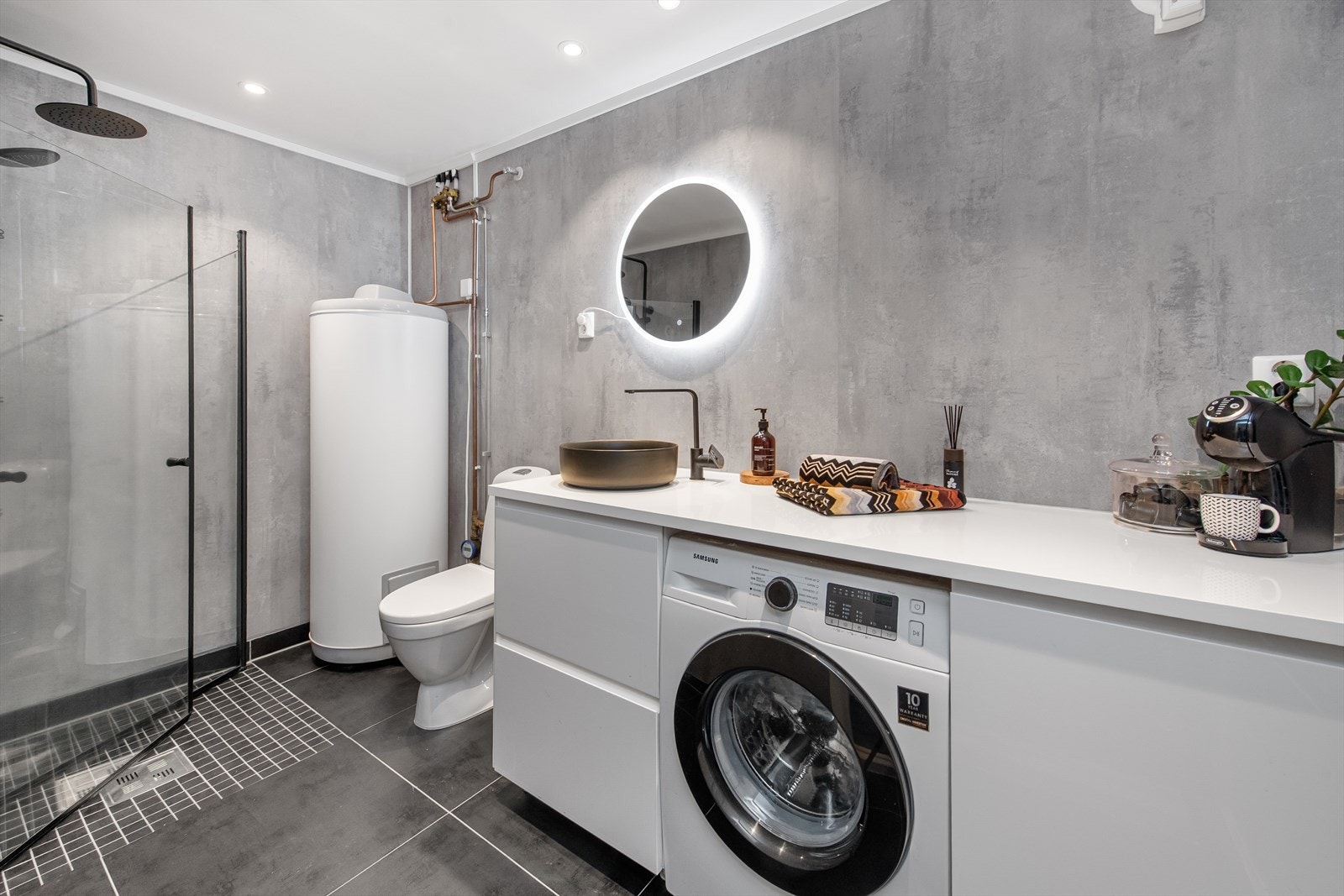 Bad med vaskeromsløsning og moderne vaskemaskin. Galleribilde