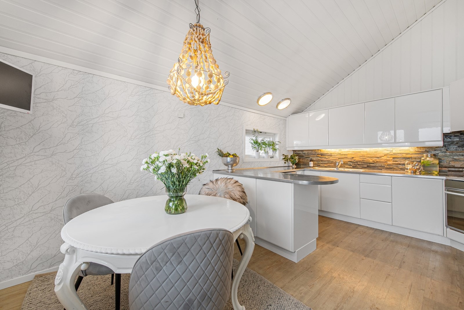 Elegant kjøkken med spiseplass og moderne innredning. Galleribilde