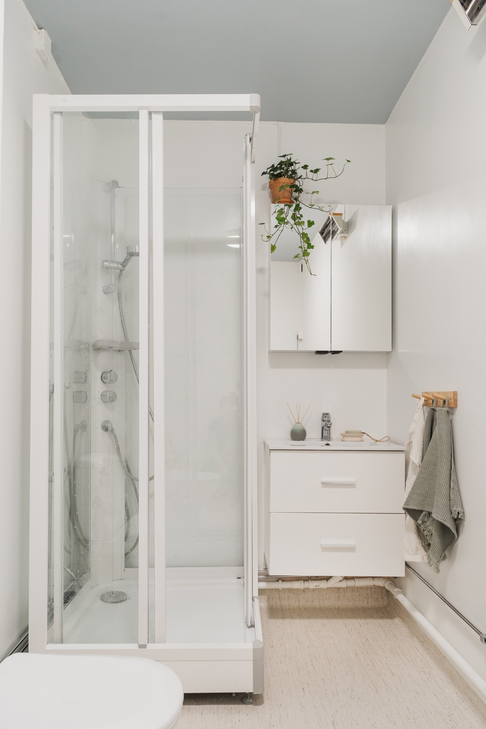 Romslig baderom med vegghengt innredning, speilskap, toalett og dusjkabinett. Galleribilde