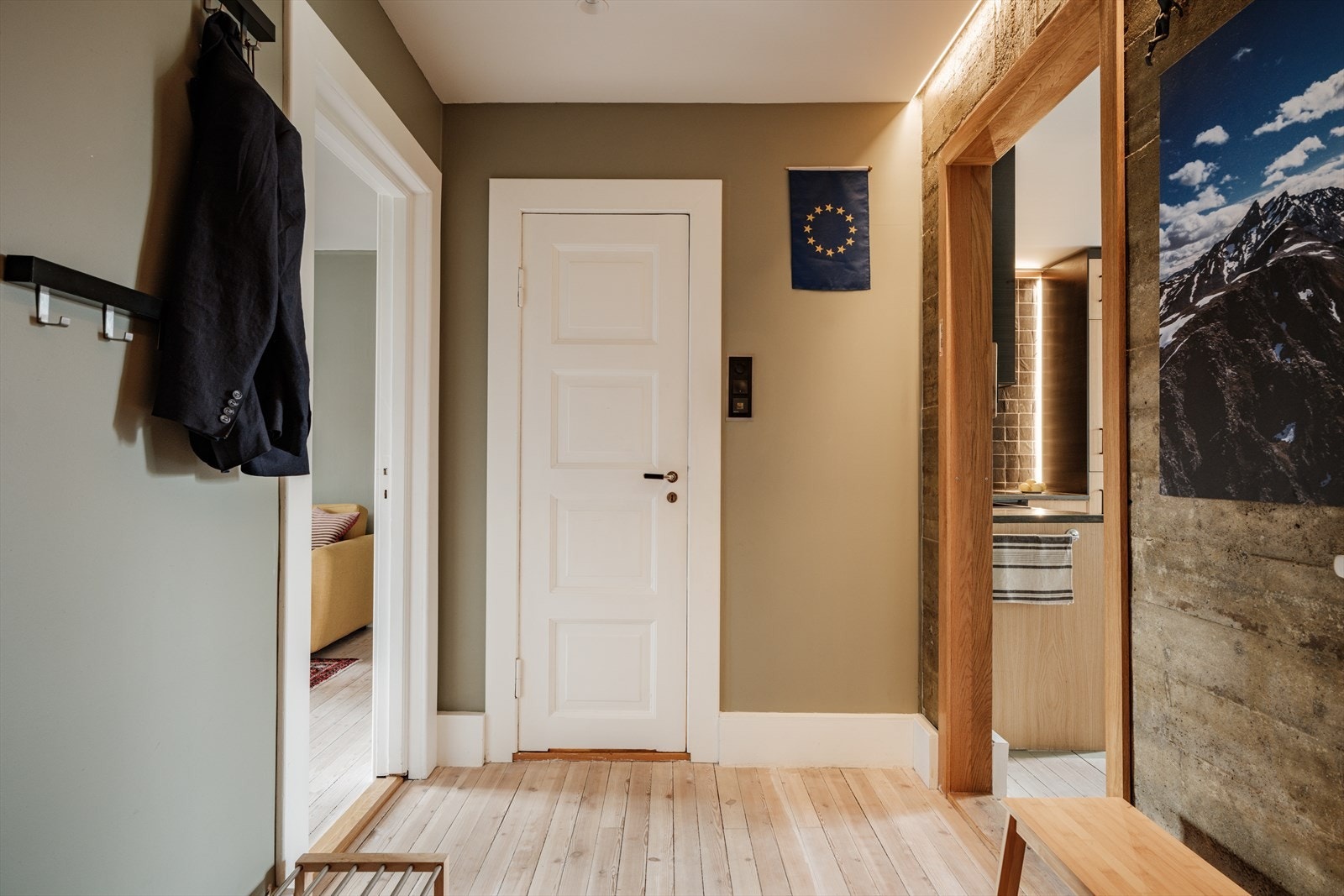 Pent originalt tregulv, malte overflater og en synlig betongvegg. Galleribilde