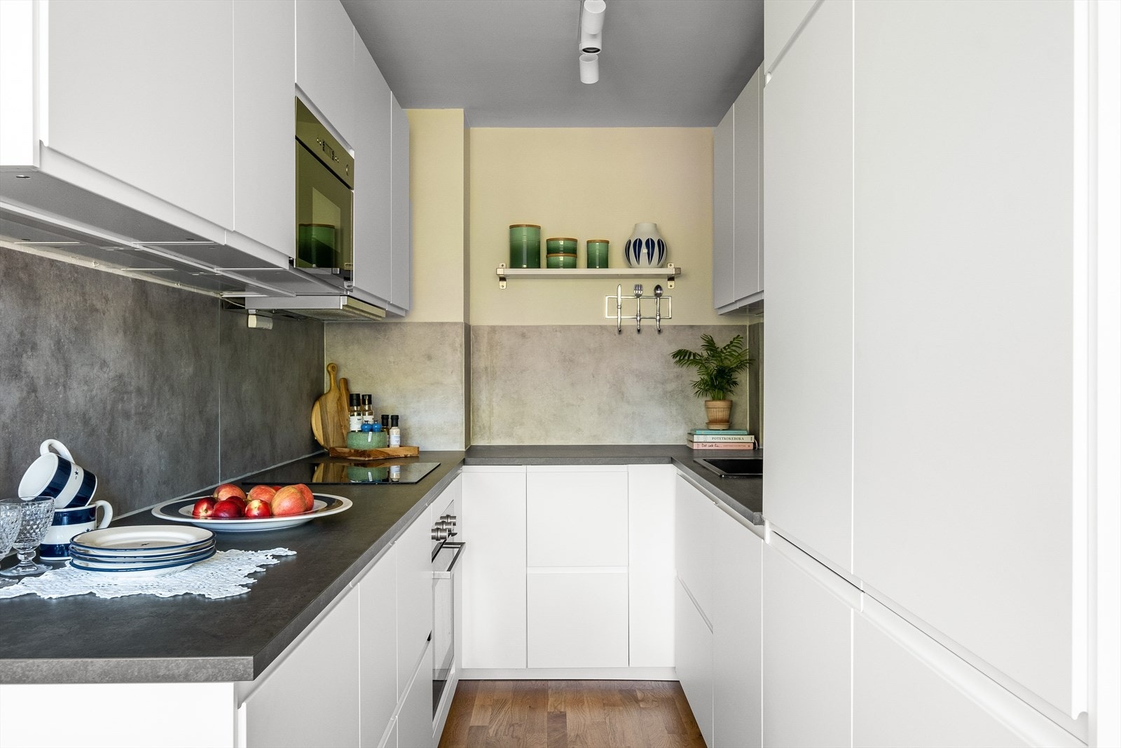 Delikat kjøkken fra 2020 med slette hvite fronter, laminat benkeplater og backsplash. Galleribilde