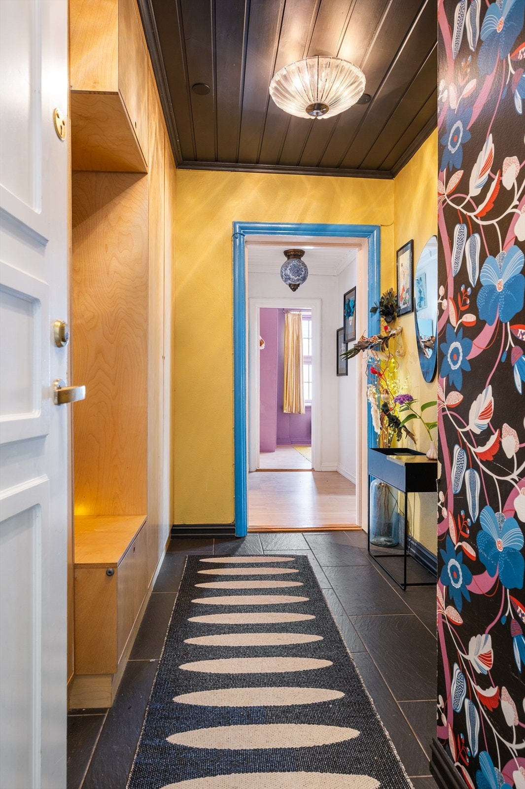 En stilren sittebenk gir både funksjonalitet og en innbydende atmosfære i entréen - perfekt for å ta av og på sko. Galleribilde