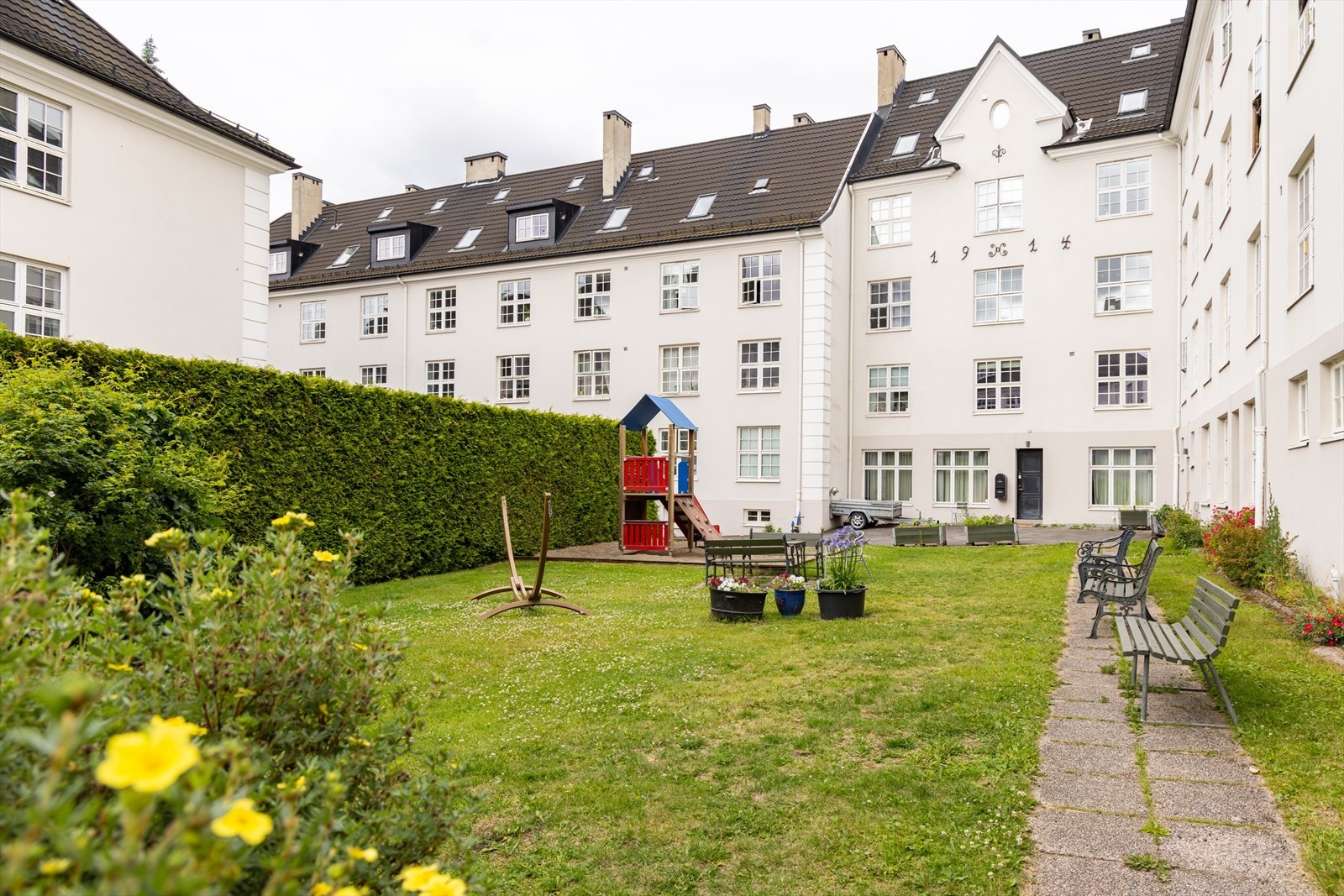 Felles gårdsrom er svært pent opparbeidet med både gressplen, gangstier og flott beplantning. Her trives både store og små. Galleribilde