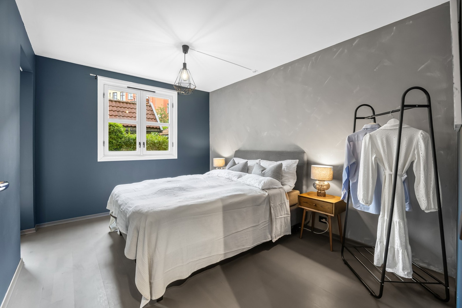 Soverom med dobbeltseng, nattbord og vindu som gir naturlig lys. Galleribilde