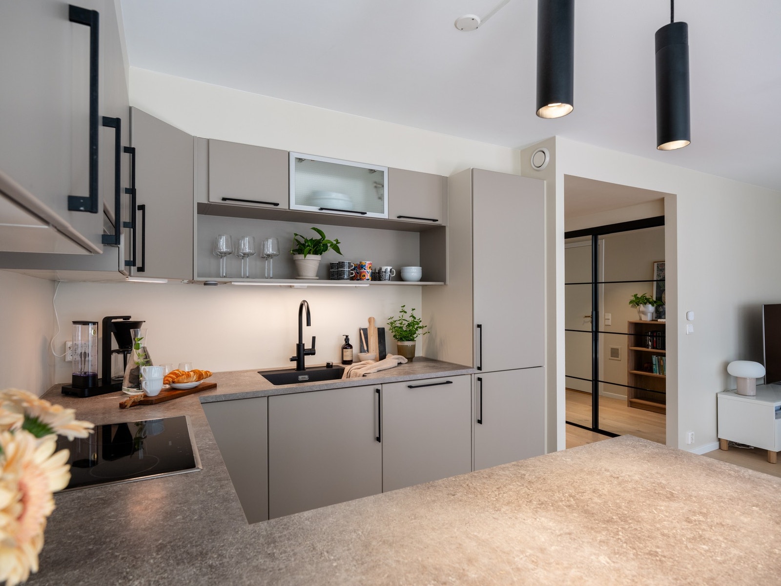 Den åpne hyllen over vasken letter på inntrykket, samtidig som det gir rikelig med oppbevaringsplass til fine glass eller lignende. Galleribilde