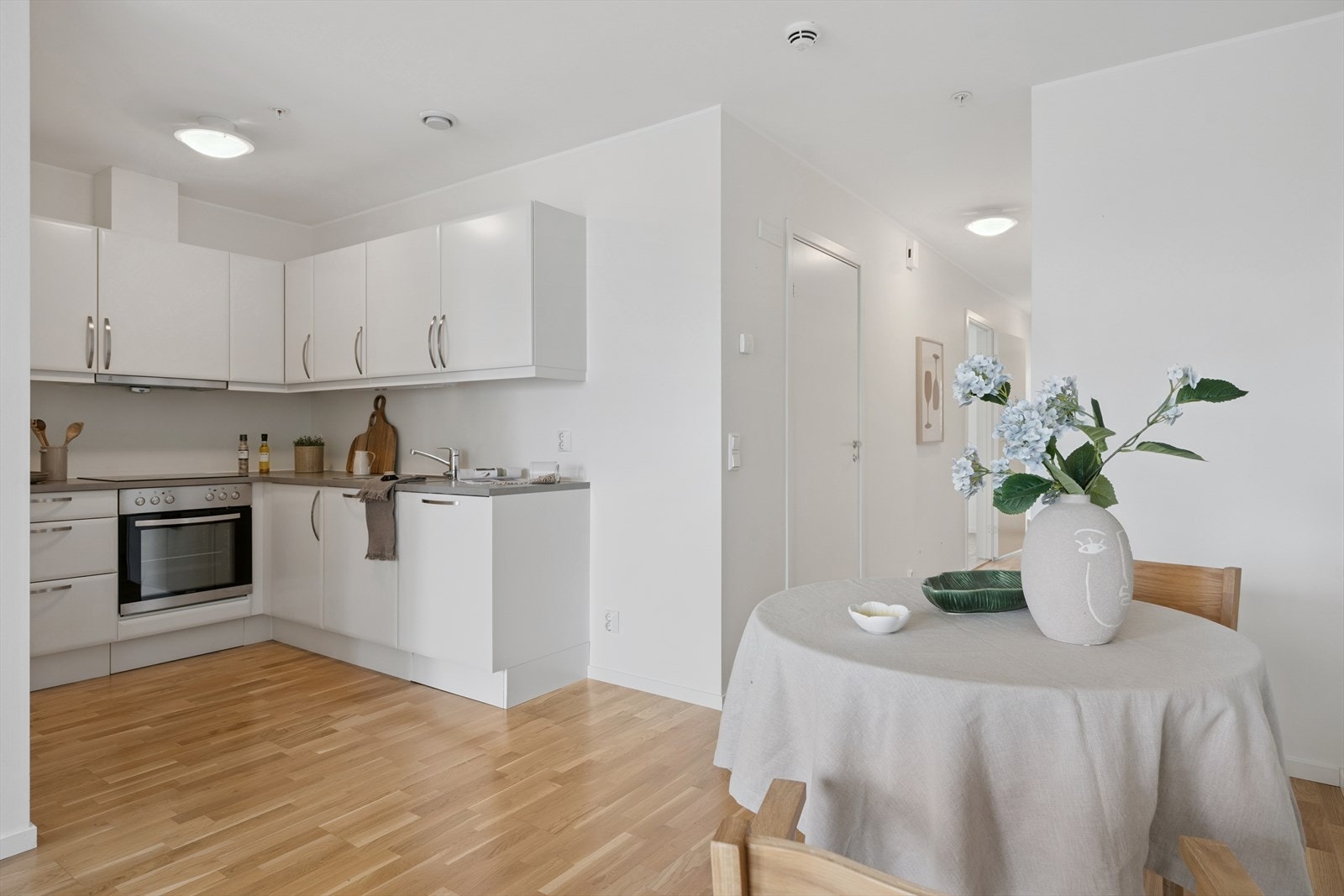 Leilighetens kjøkken har innredning fra HTH med slette fronter og benkeplater av laminat Galleribilde