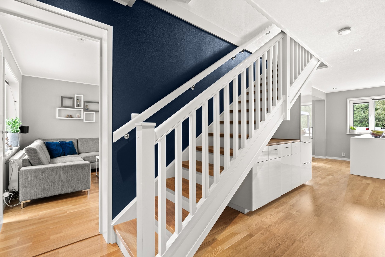Fra entréen fører en pen trapp med hvitmalt rekkverk og trinn i heltre videre opp i boligen. Galleribilde