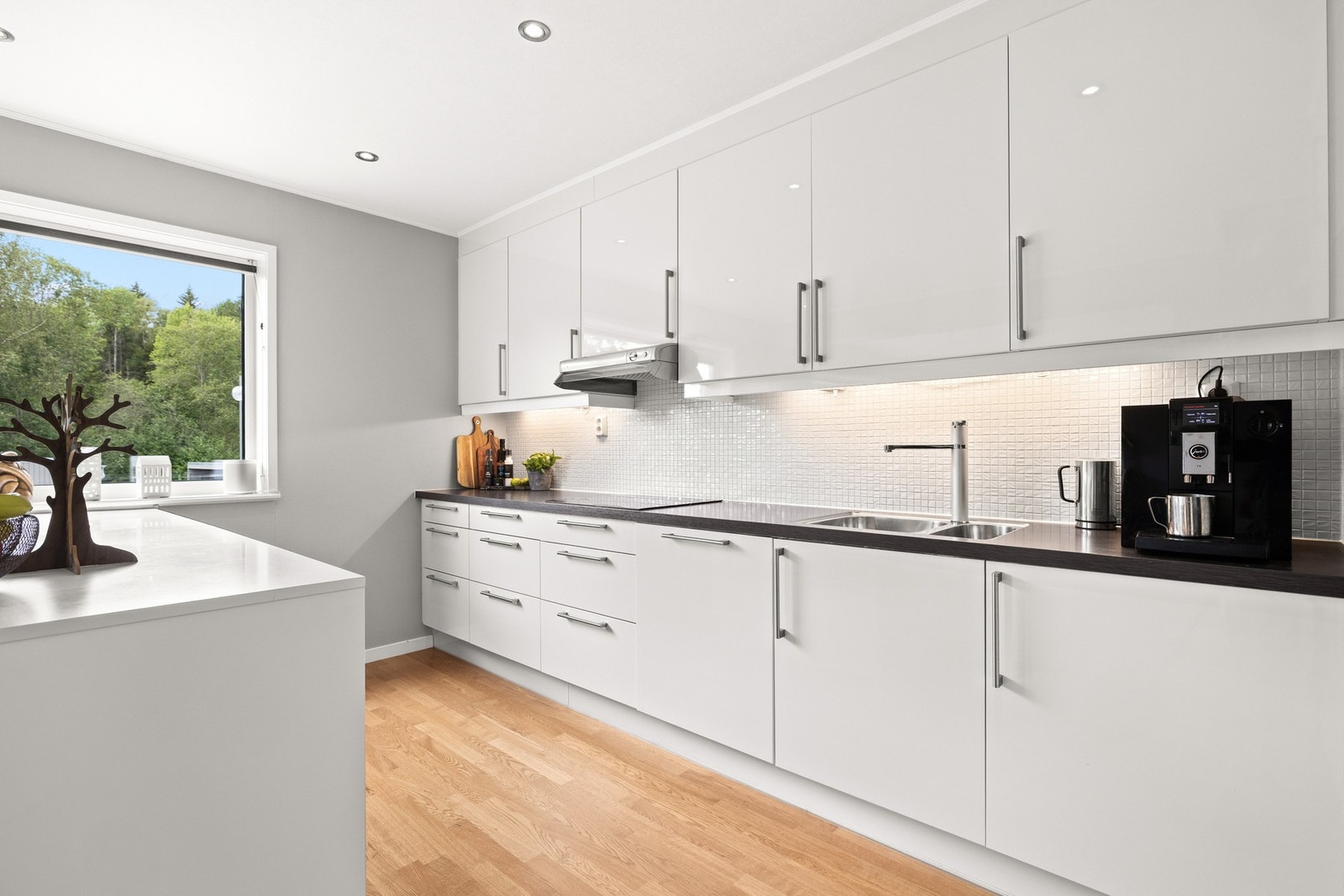 Over benkeplaten er det lagt fliser, og under overskapene er det montert downlights som gir godt arbeidslys. Galleribilde