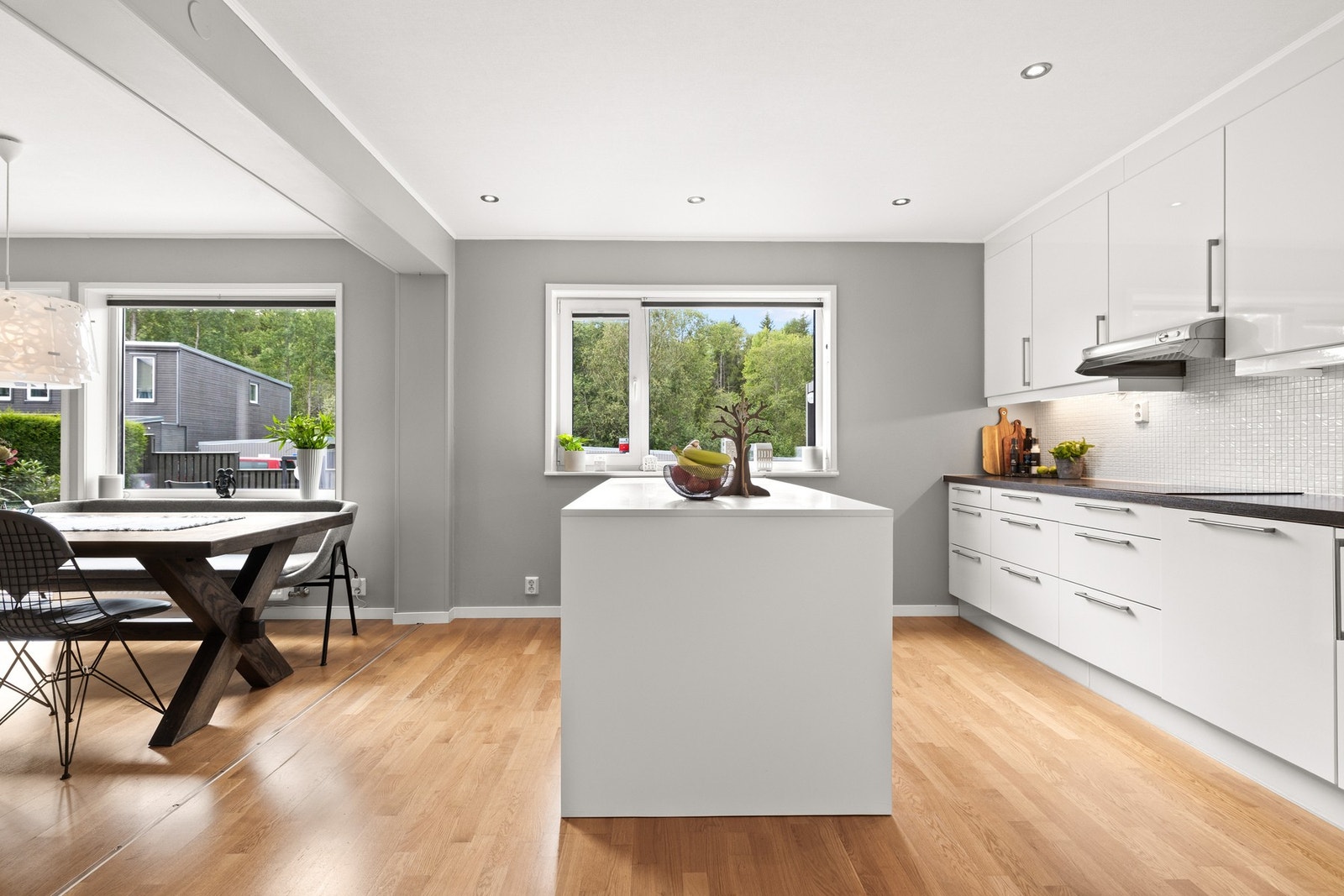 Innredningen har glatte, folierte fronter i hvit høyglans kombinert med laminat benkeplate og planlimt kum i rustfritt stål. Galleribilde