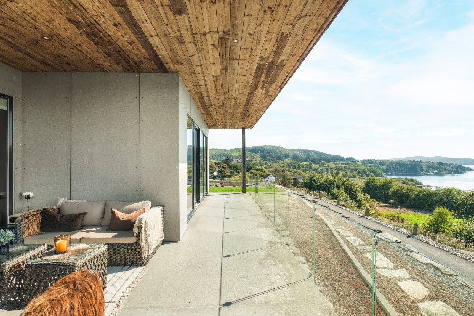 Delvis overbygget terrasse med glass rekkverk. Galleribilde